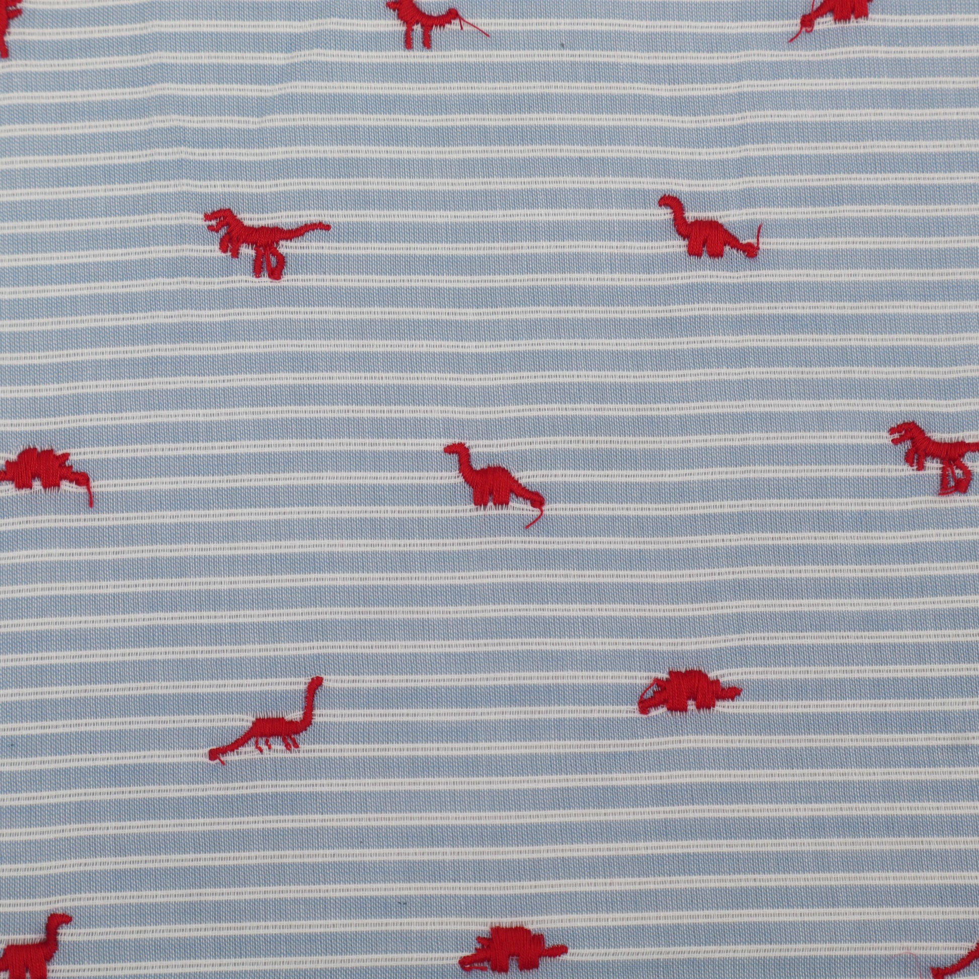 Fabric with red dinosaur patterns on a blue and white striped background