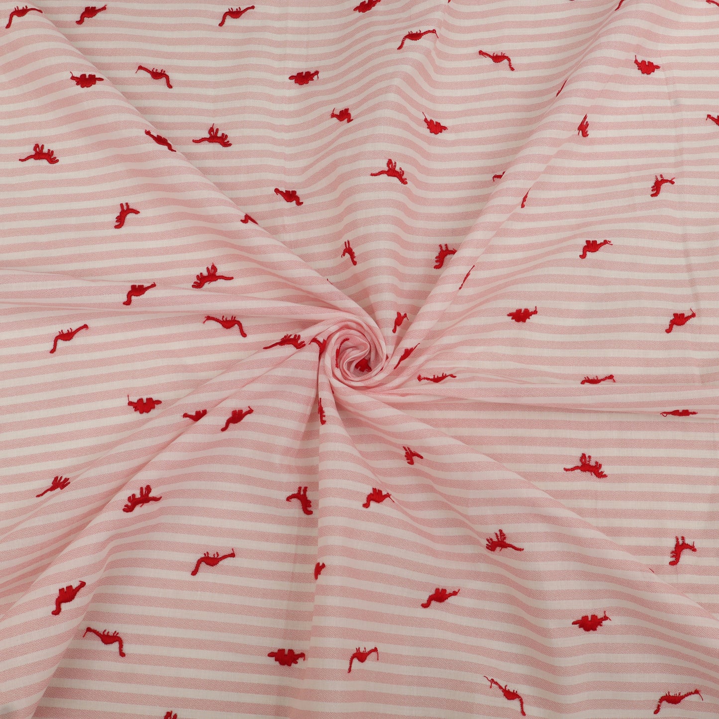 Pink fabric with red pattern, possibly of a child's garment
