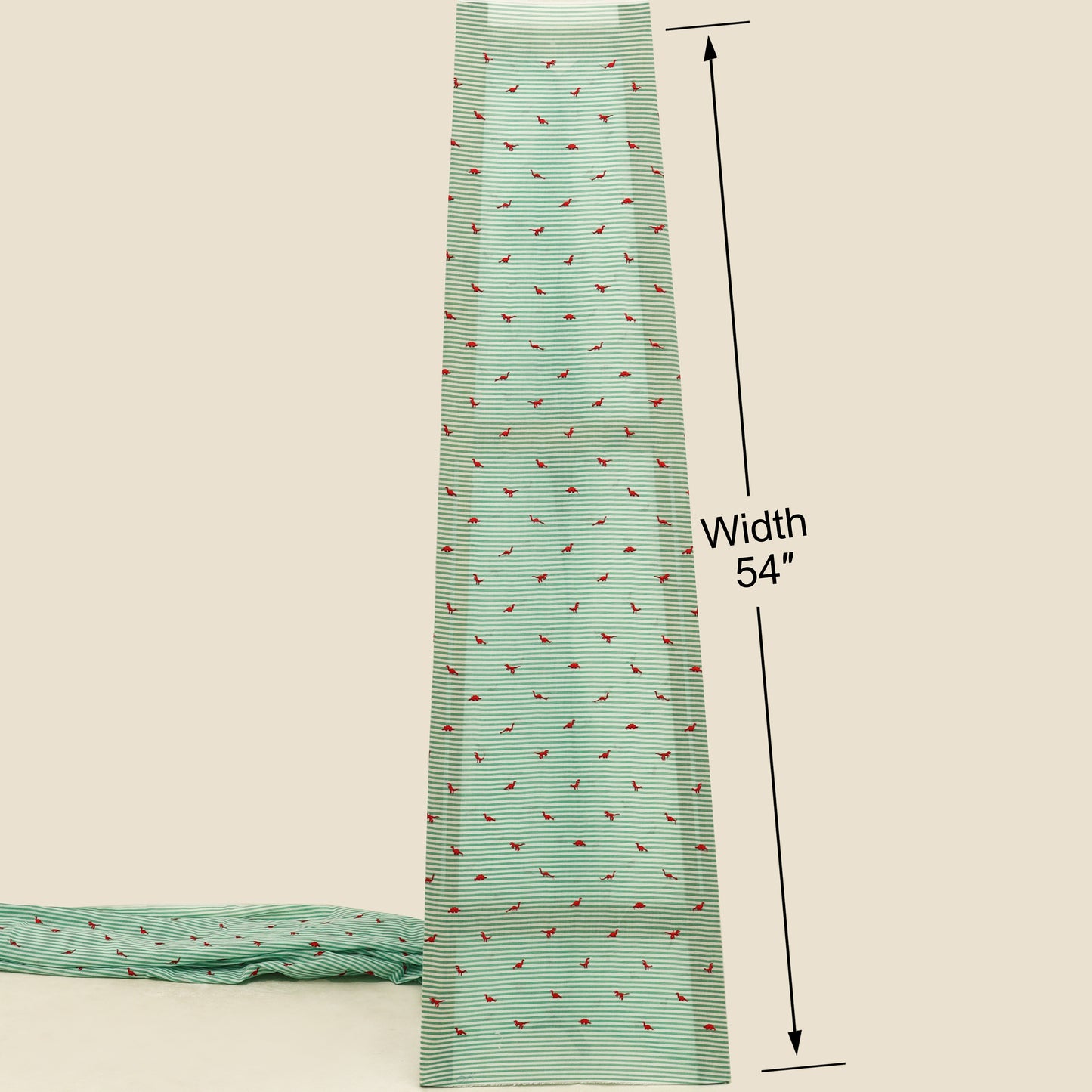 Green fabric with red pattern and measurement label on a beige background