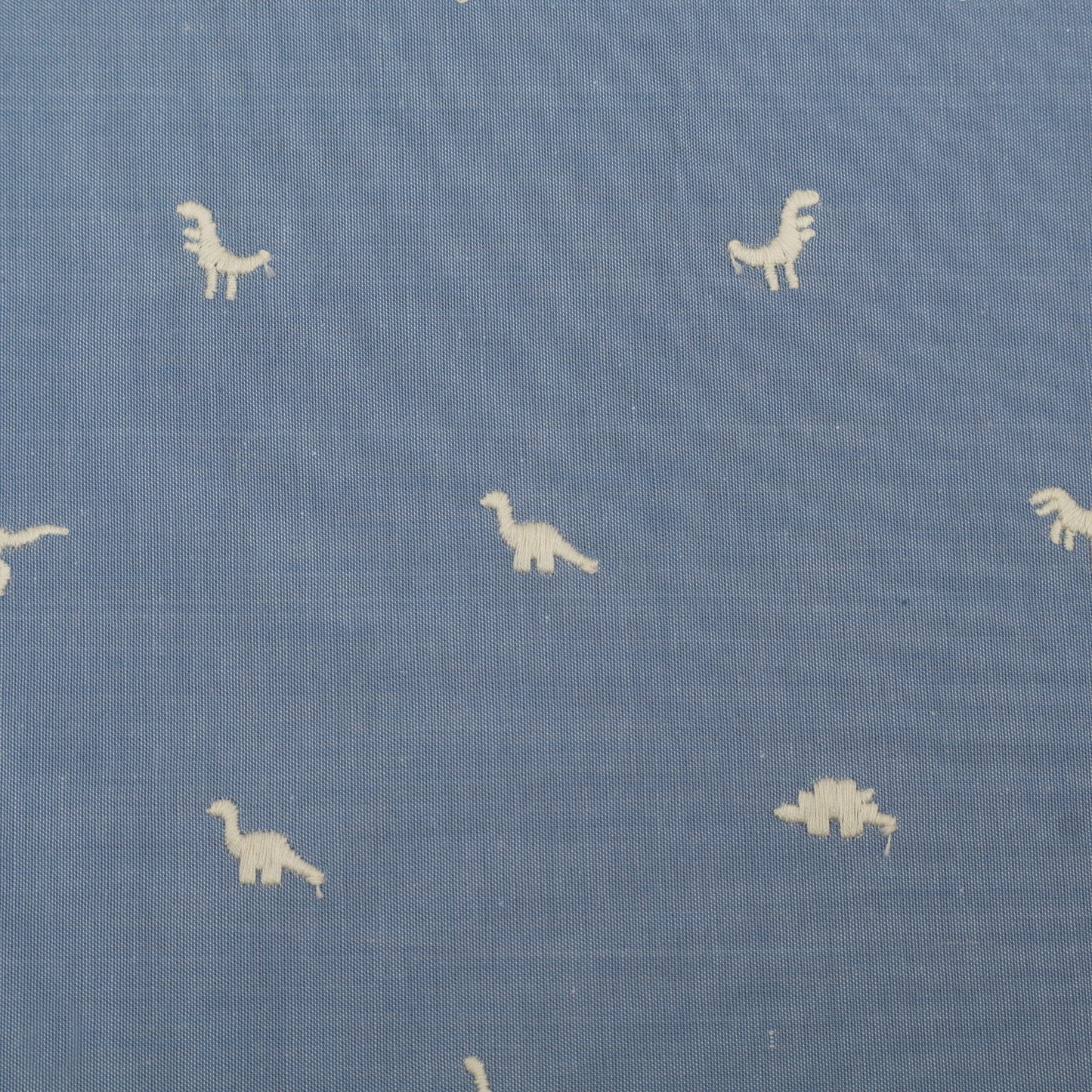 Blue fabric with small white dinosaur prints