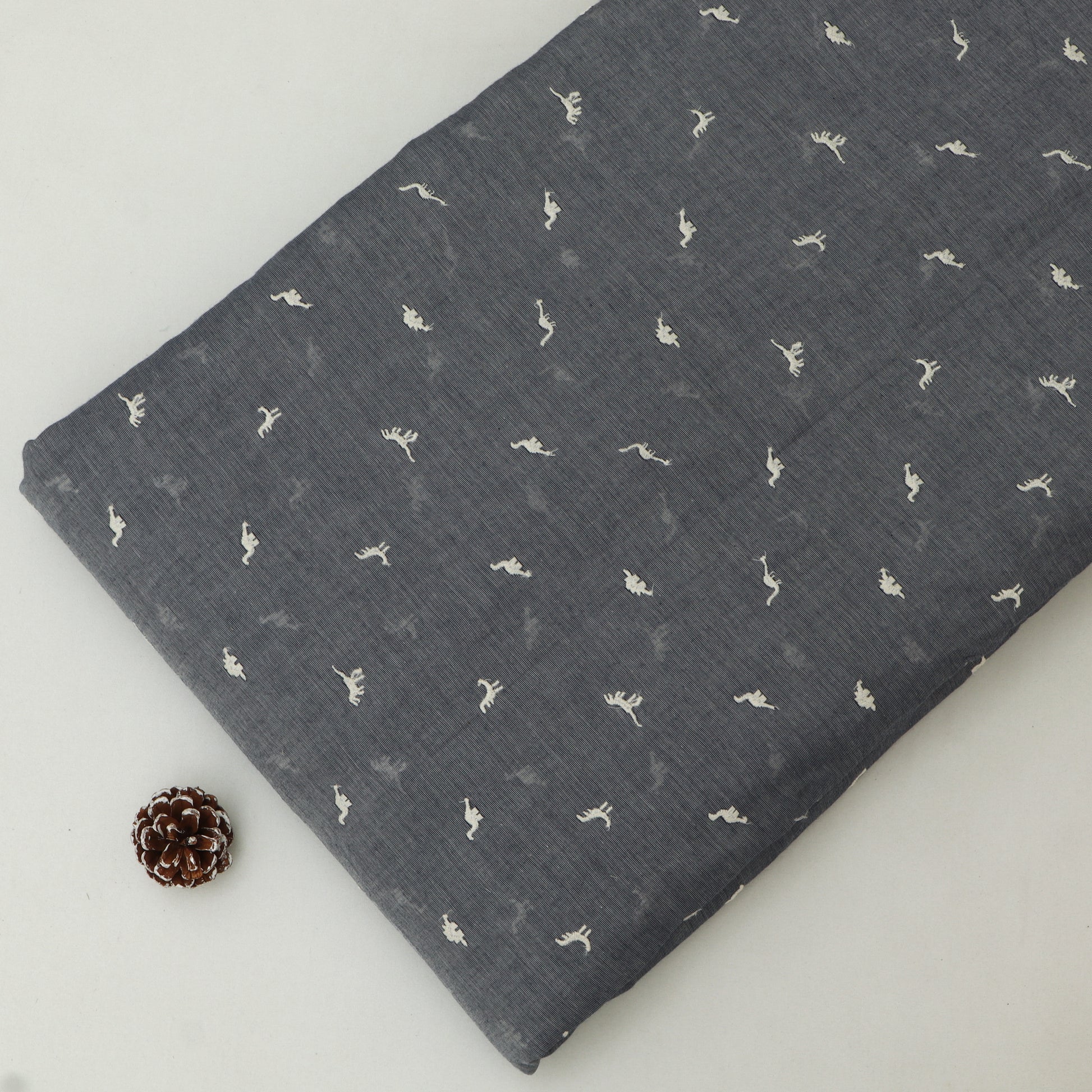 Dark gray fabric with small white patterns on a light gray background