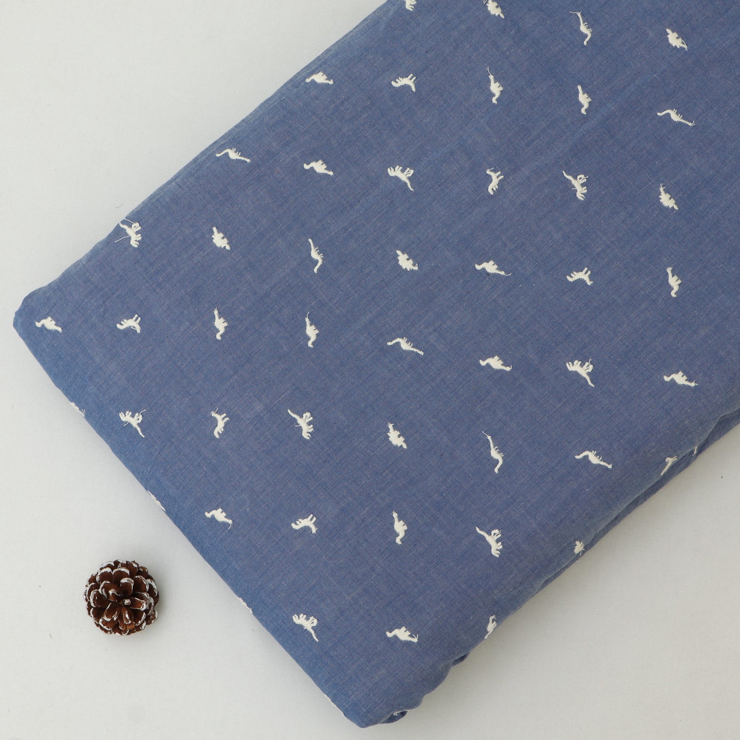 Blue fabric with white patterns on a light gray background