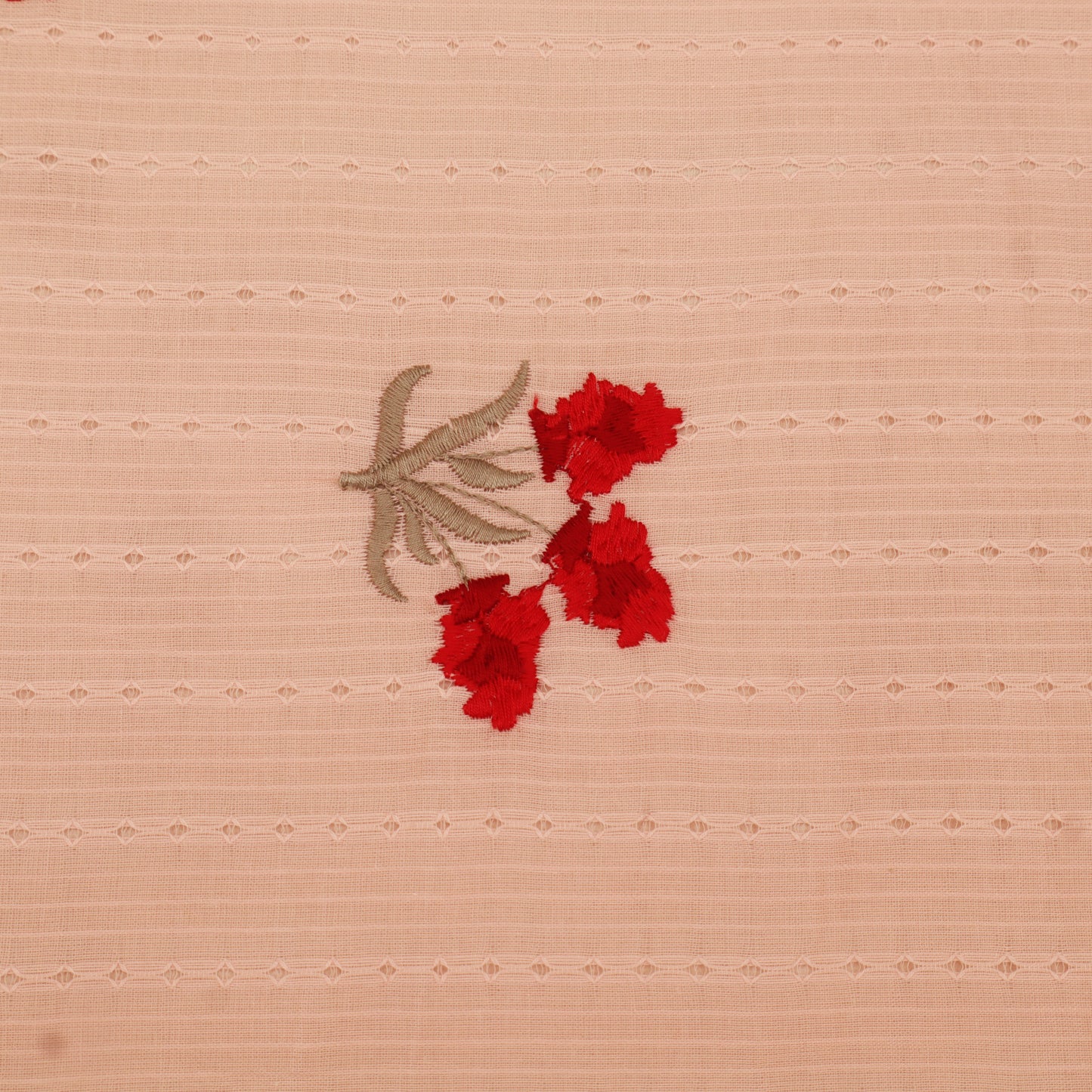 Embroidered red flowers on a beige fabric background