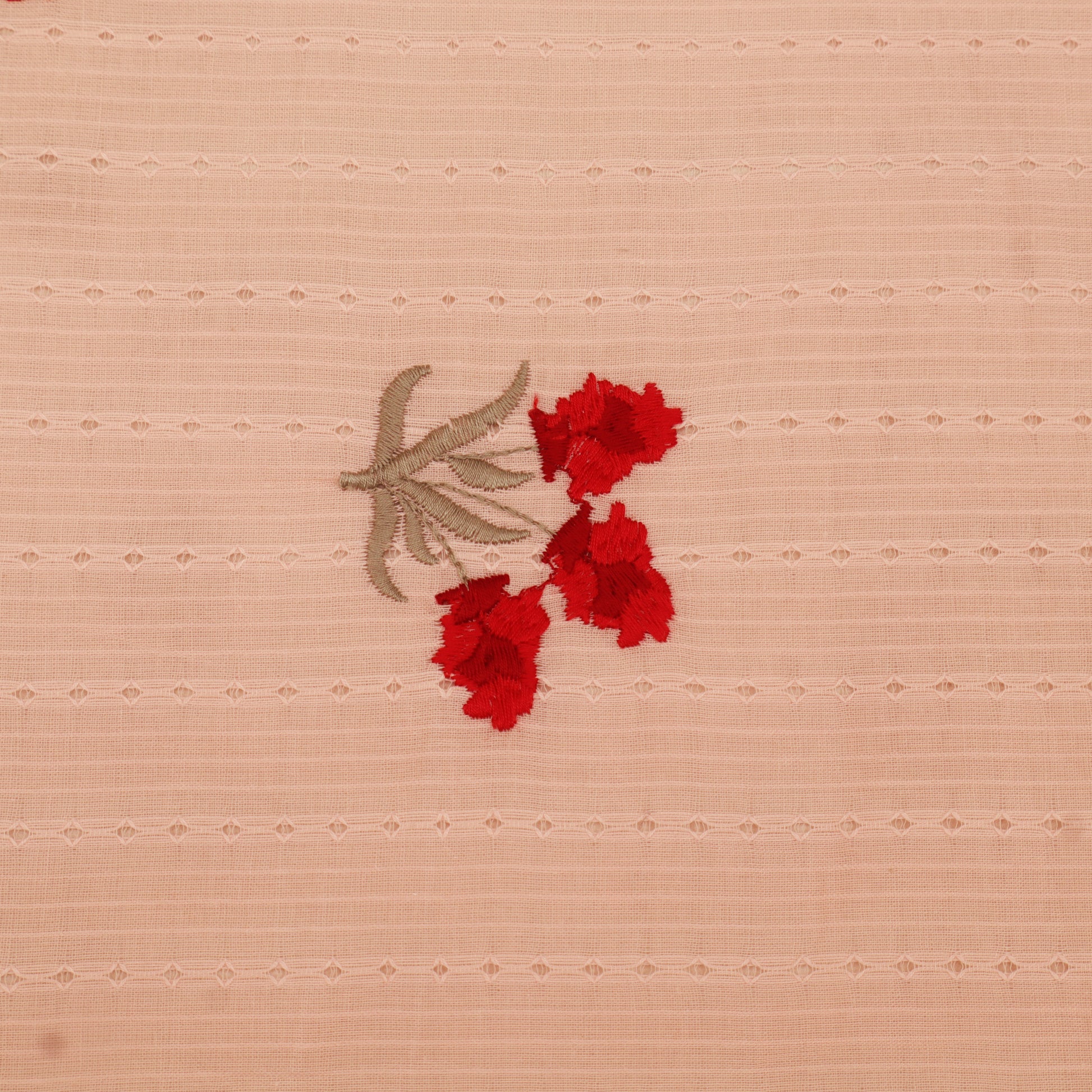 Embroidered red flowers on a beige fabric background