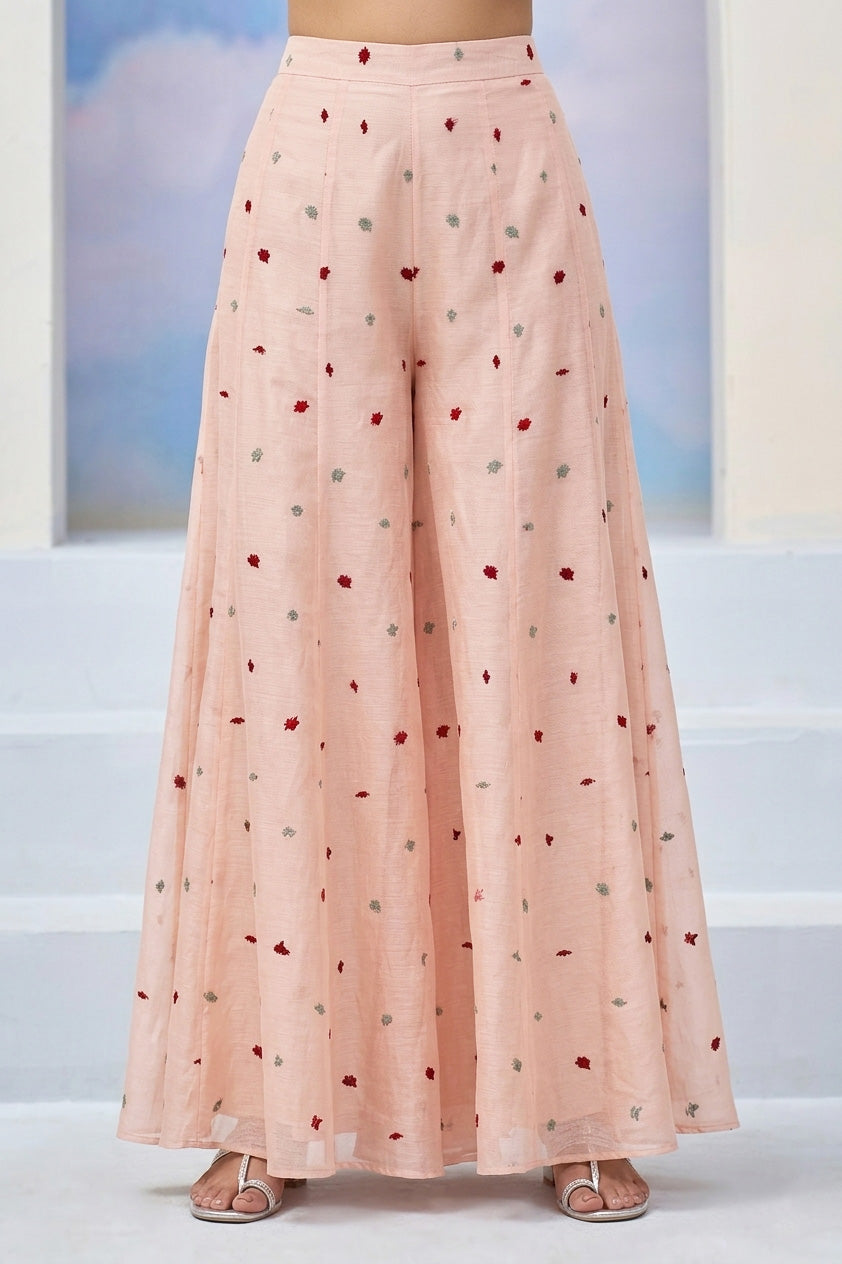 Long pink skirt with small red and green patterns on a light background