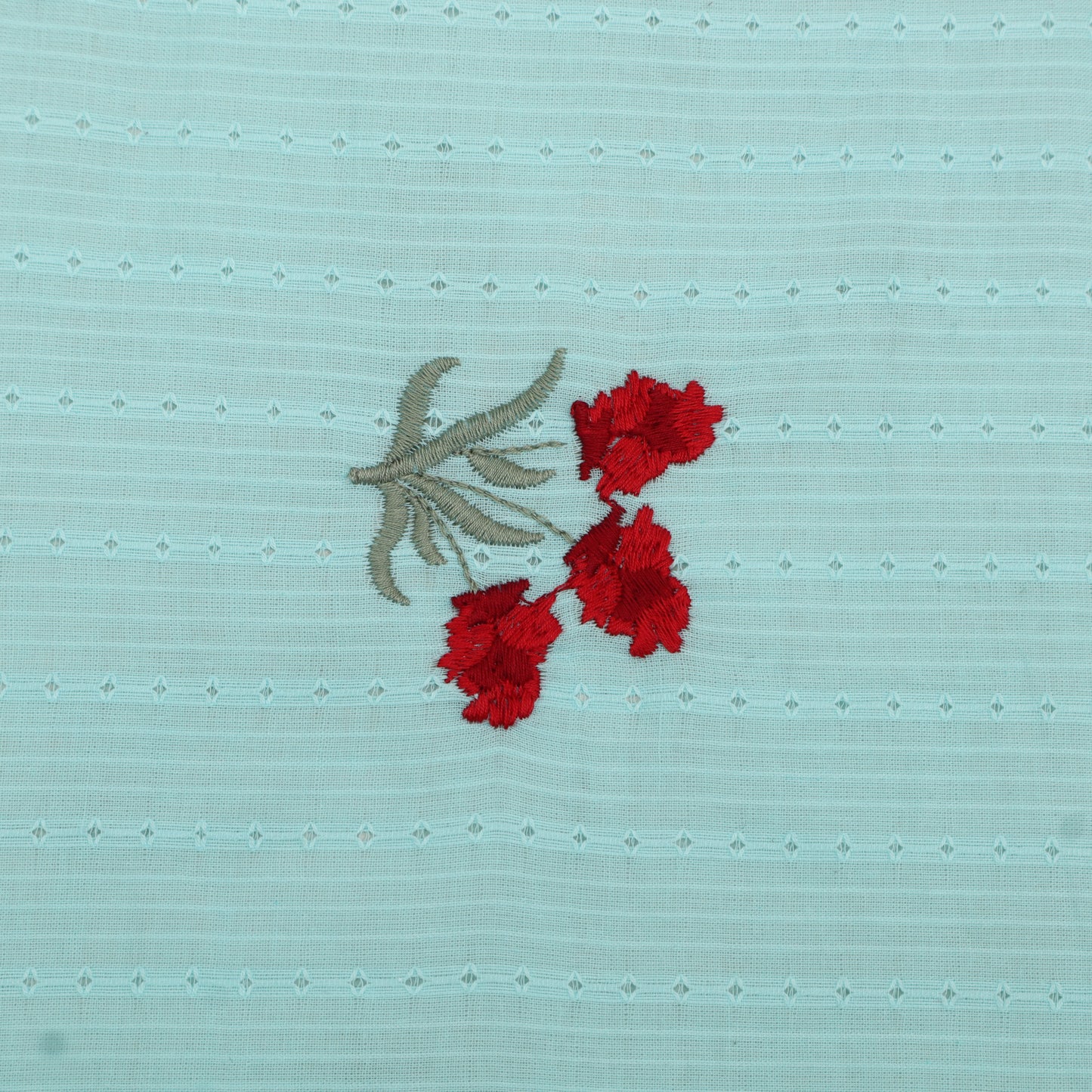 Embroidered red flowers on a light blue fabric background