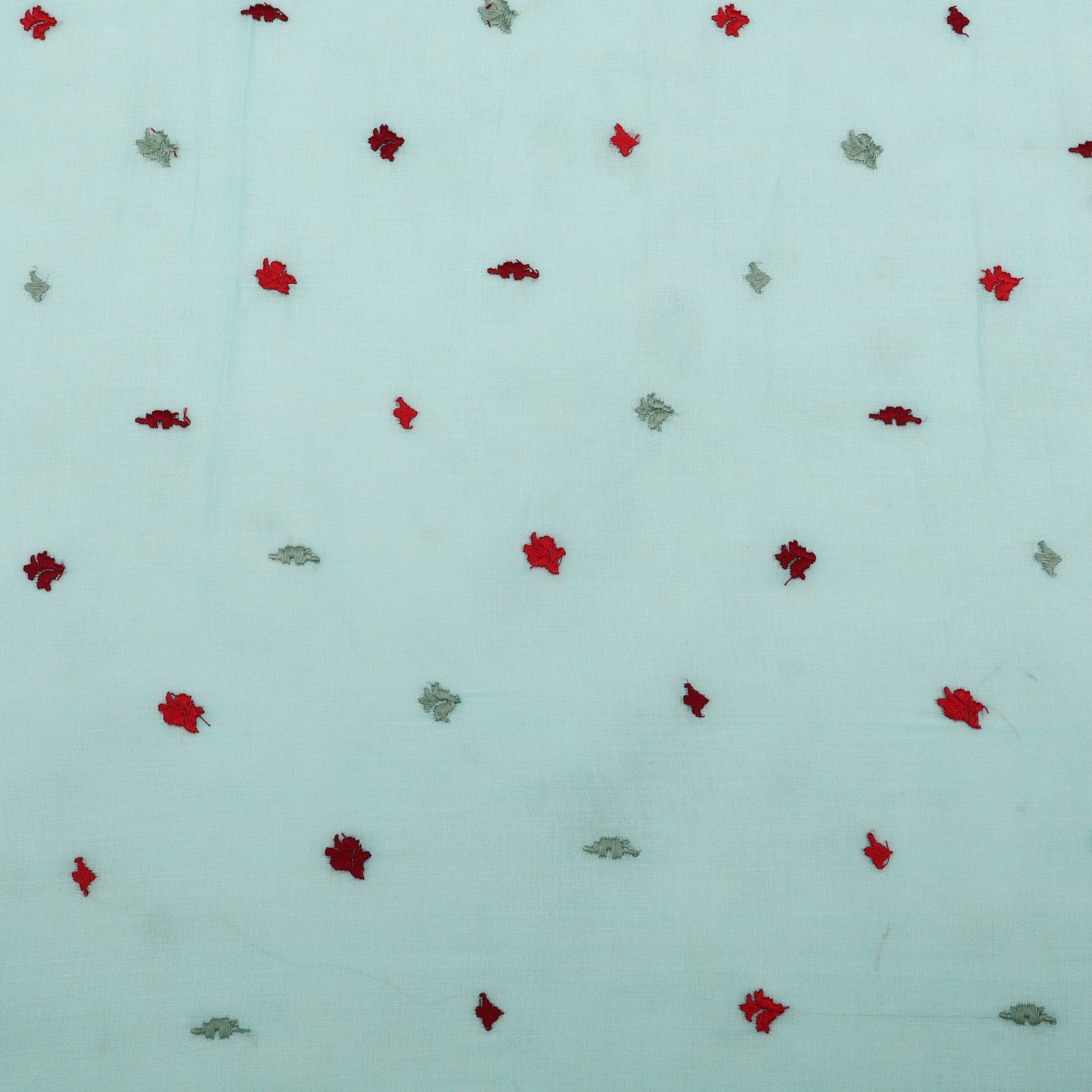 Pattern of red and green leaves on a light blue background