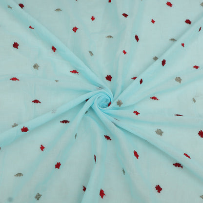 Light blue fabric with small red and gray floral patterns, folded in a swirl.