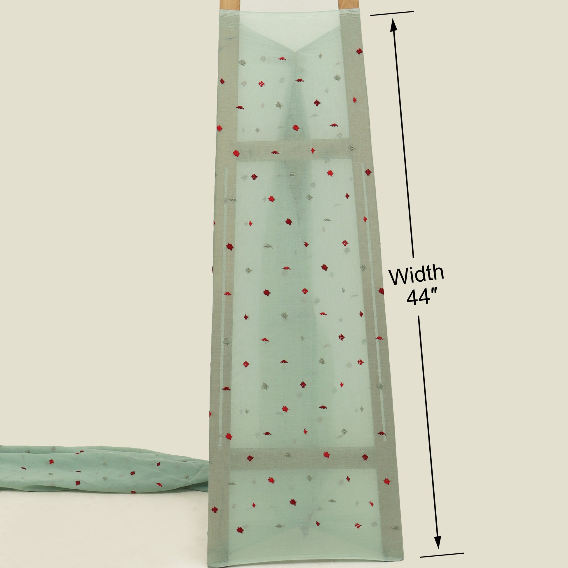 Mint green fabric with red floral pattern and measurement label on a beige background