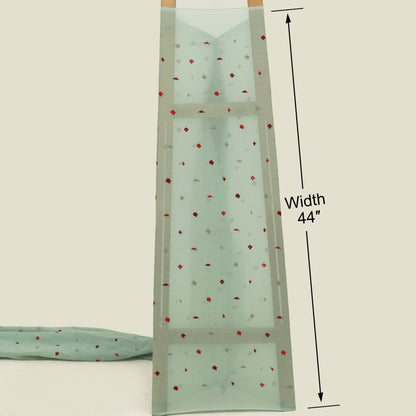 Mint green fabric with red floral pattern and measurement label on a beige background