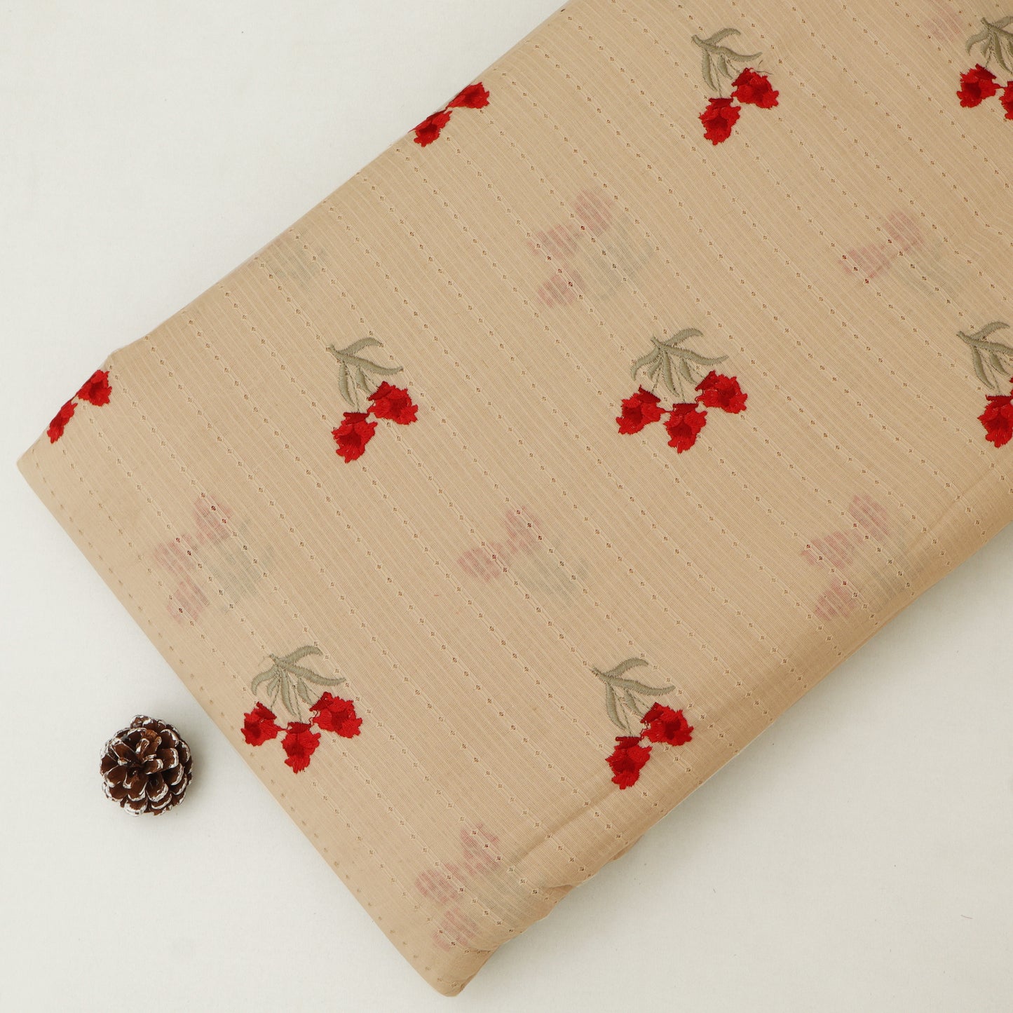 Beige fabric with red floral patterns on a white background