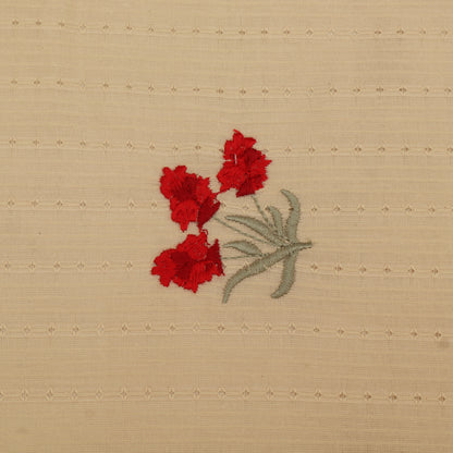 Embroidered design of red flowers on beige fabric