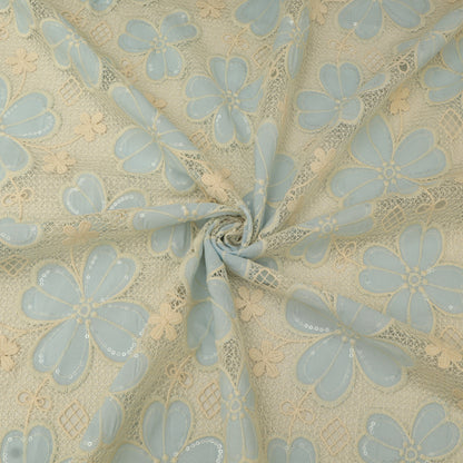Floral lace fabric with light blue flowers on a beige background
