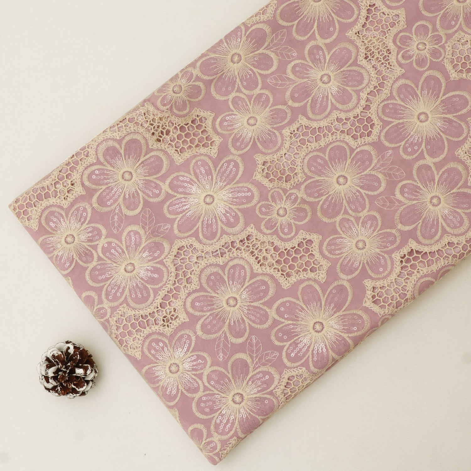 Fabric with floral lace pattern on a pink background