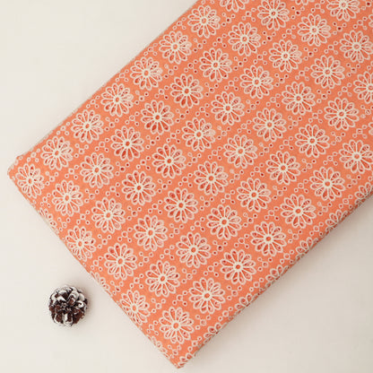 Fabric with white floral pattern on a peach background
