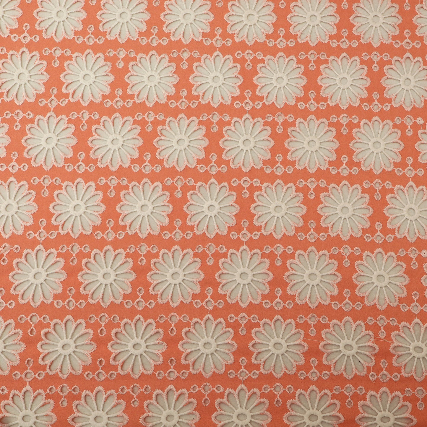 Pattern of white flowers on a coral background