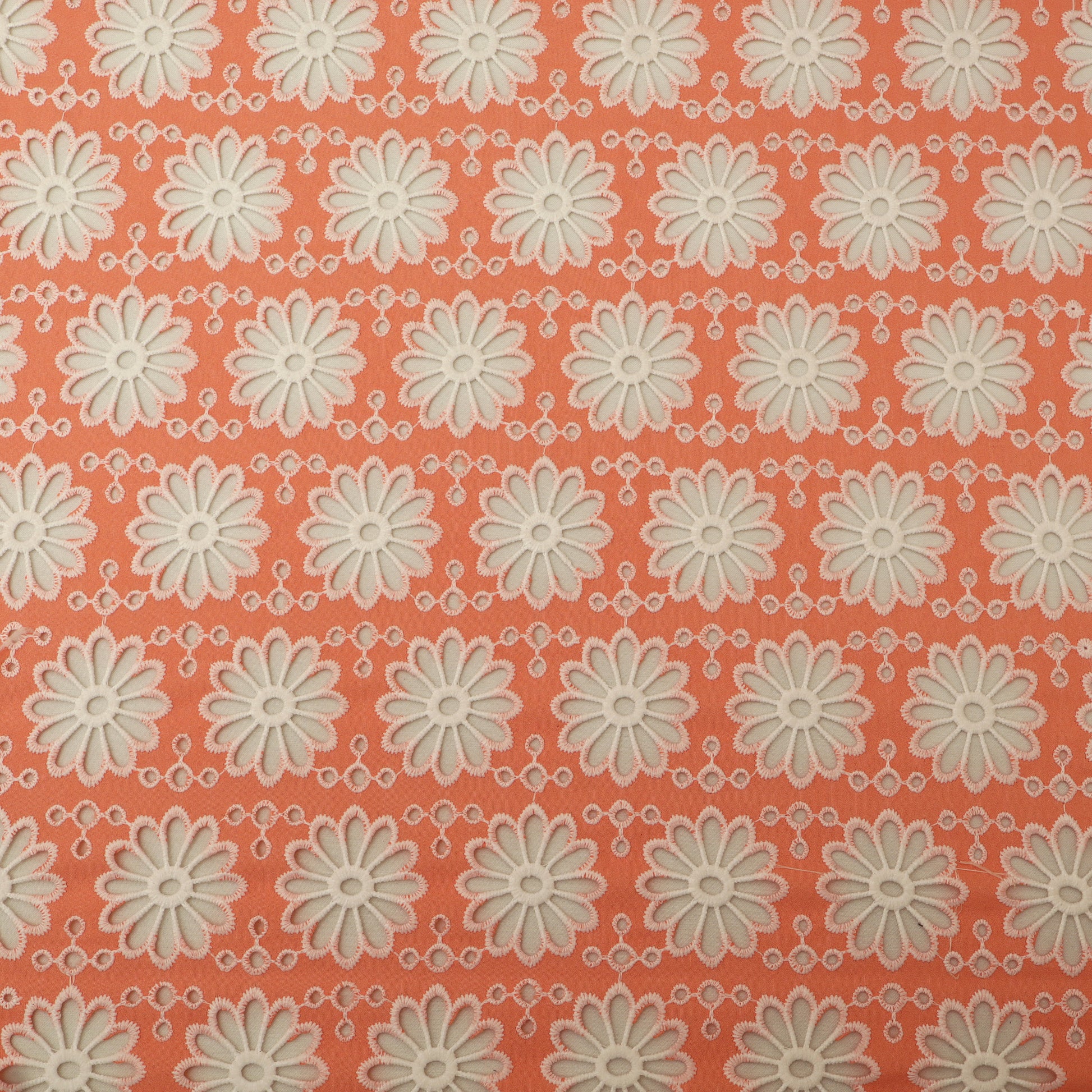 Pattern of white flowers on a coral background