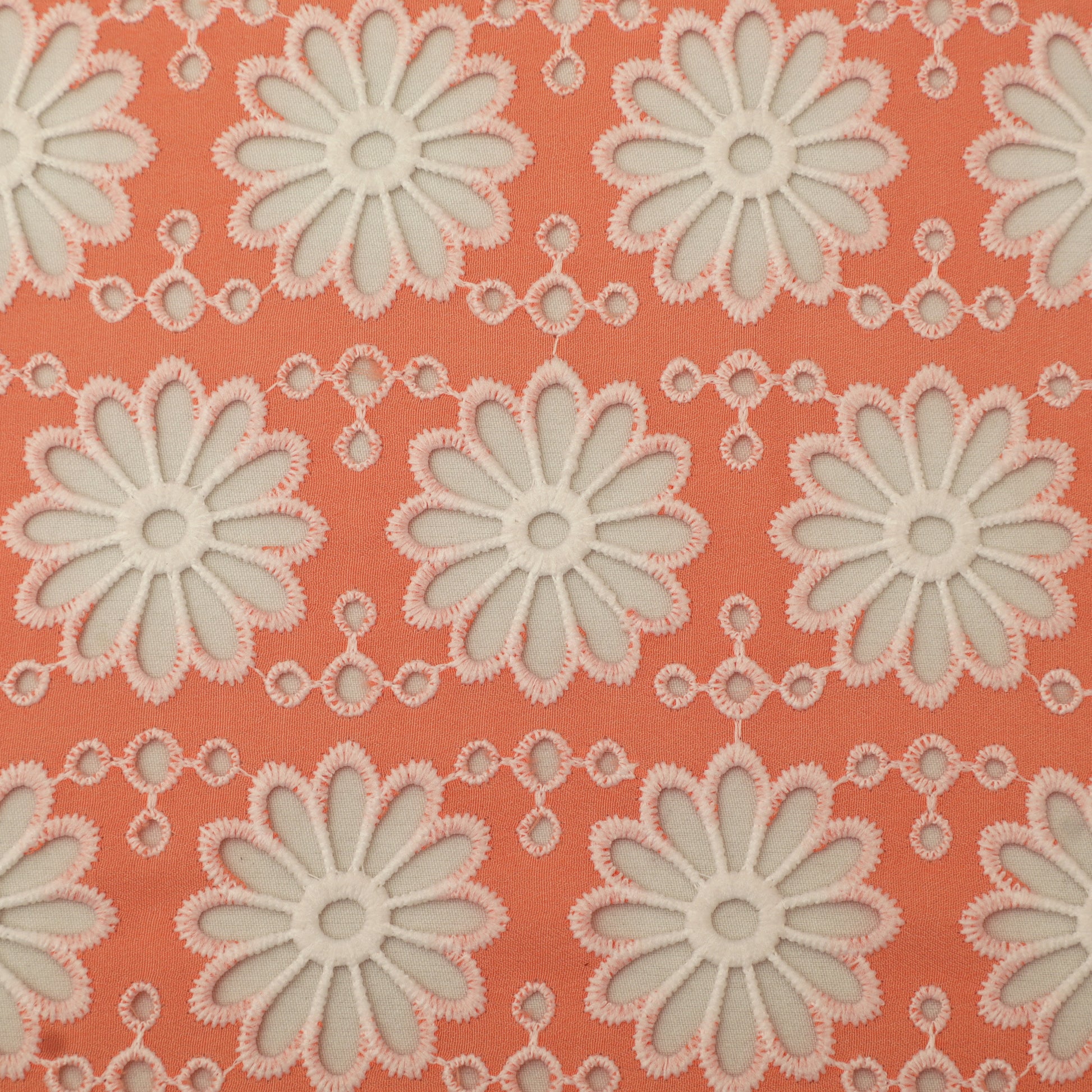 Pattern of white flowers on a coral background