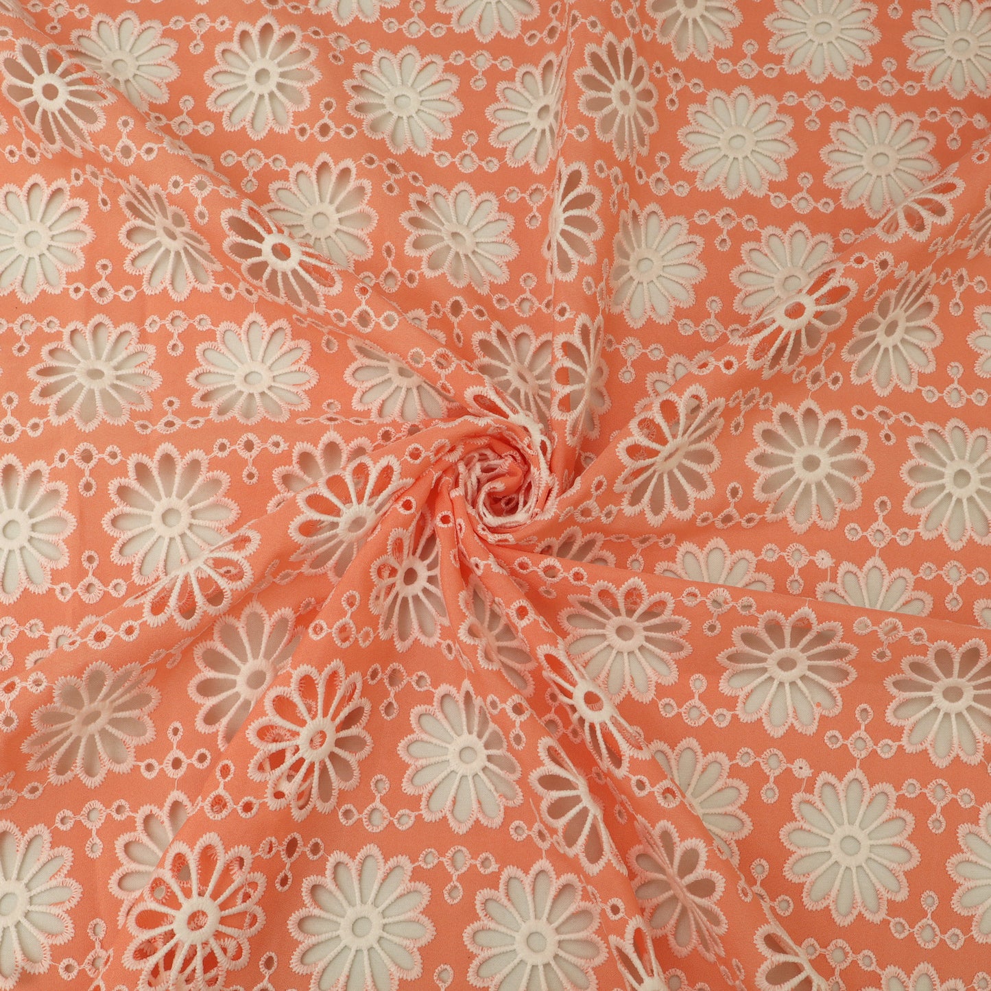 Floral patterned fabric with white flowers on a peach background