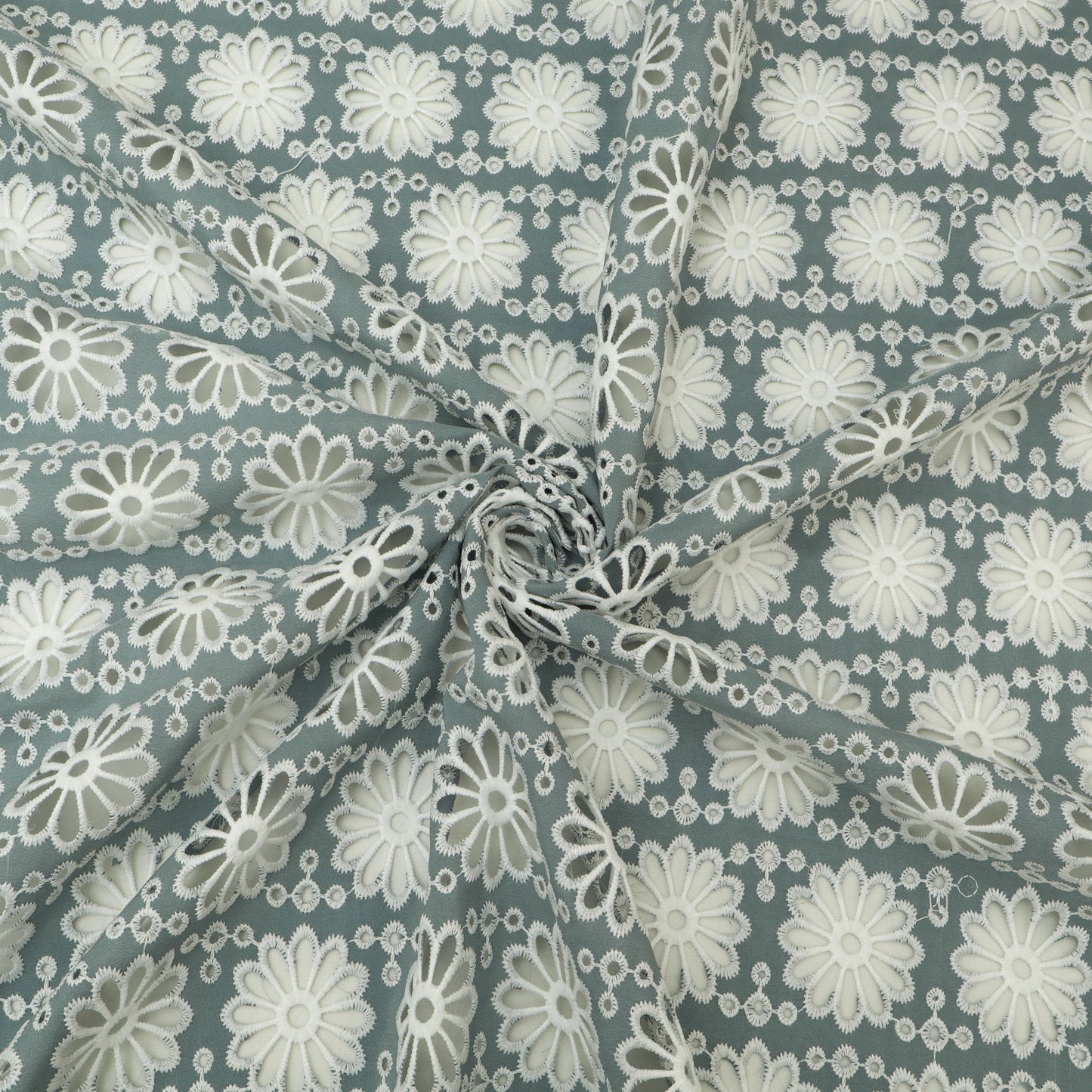 Fabric with white floral pattern on a blue-green background
