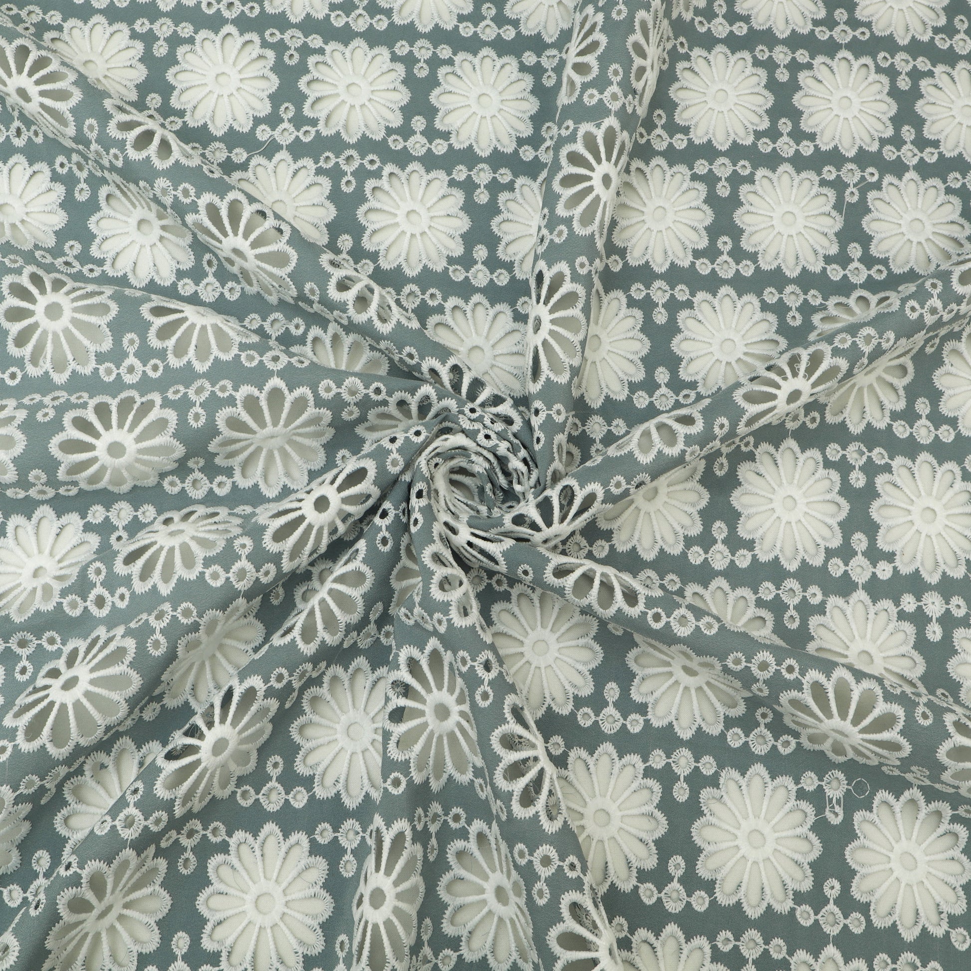 Fabric with white floral pattern on a blue-green background