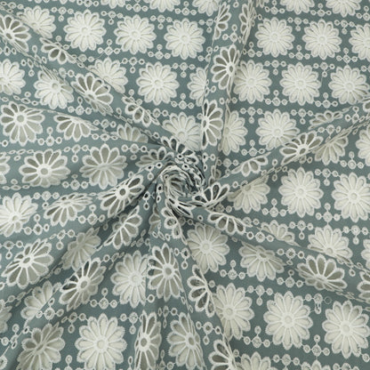 Fabric with white floral pattern on a blue-green background