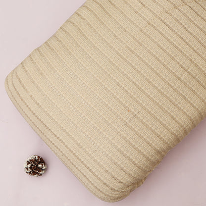 Beige textured pillow on a light pink background with a pine cone.