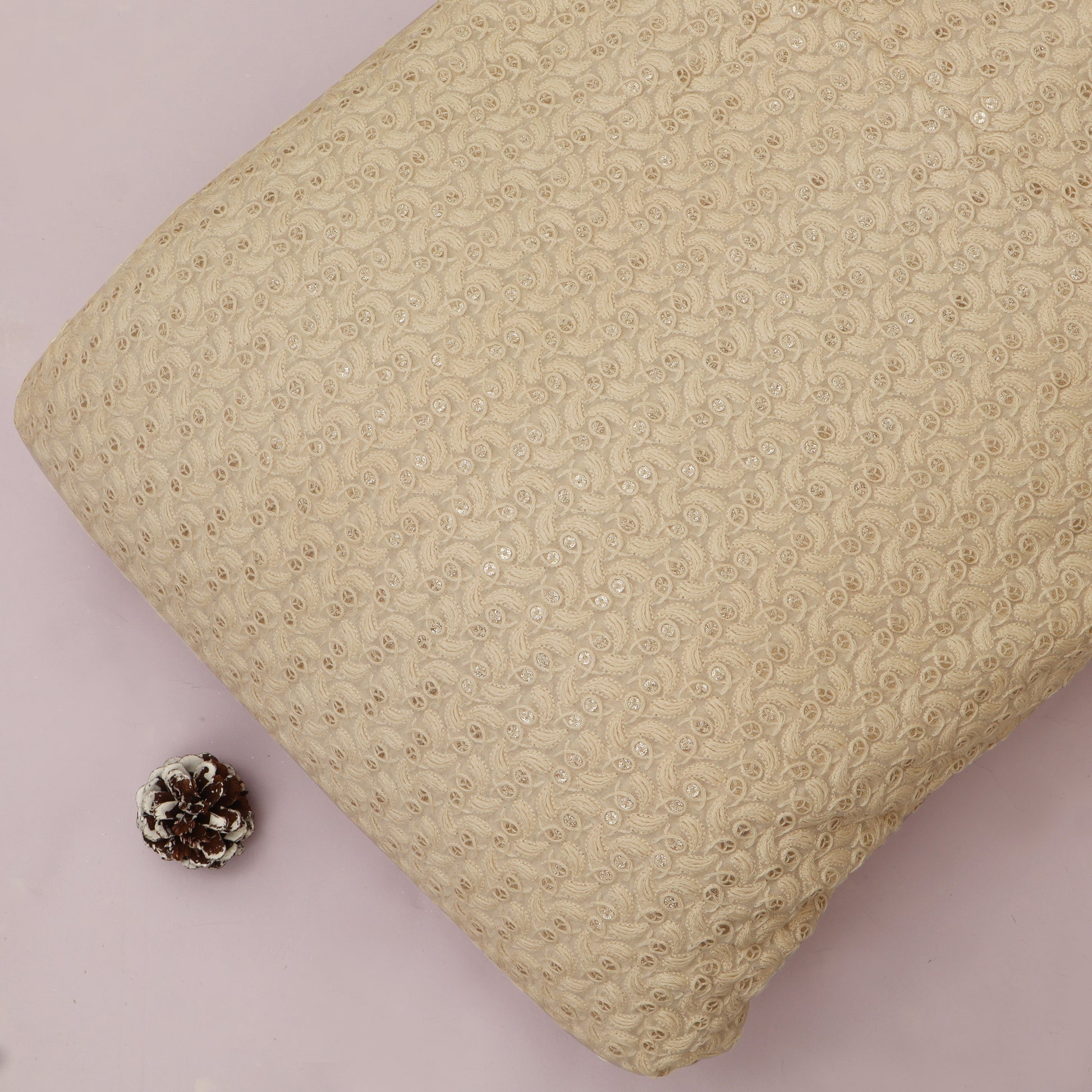 Beige textured pillow on a light pink background