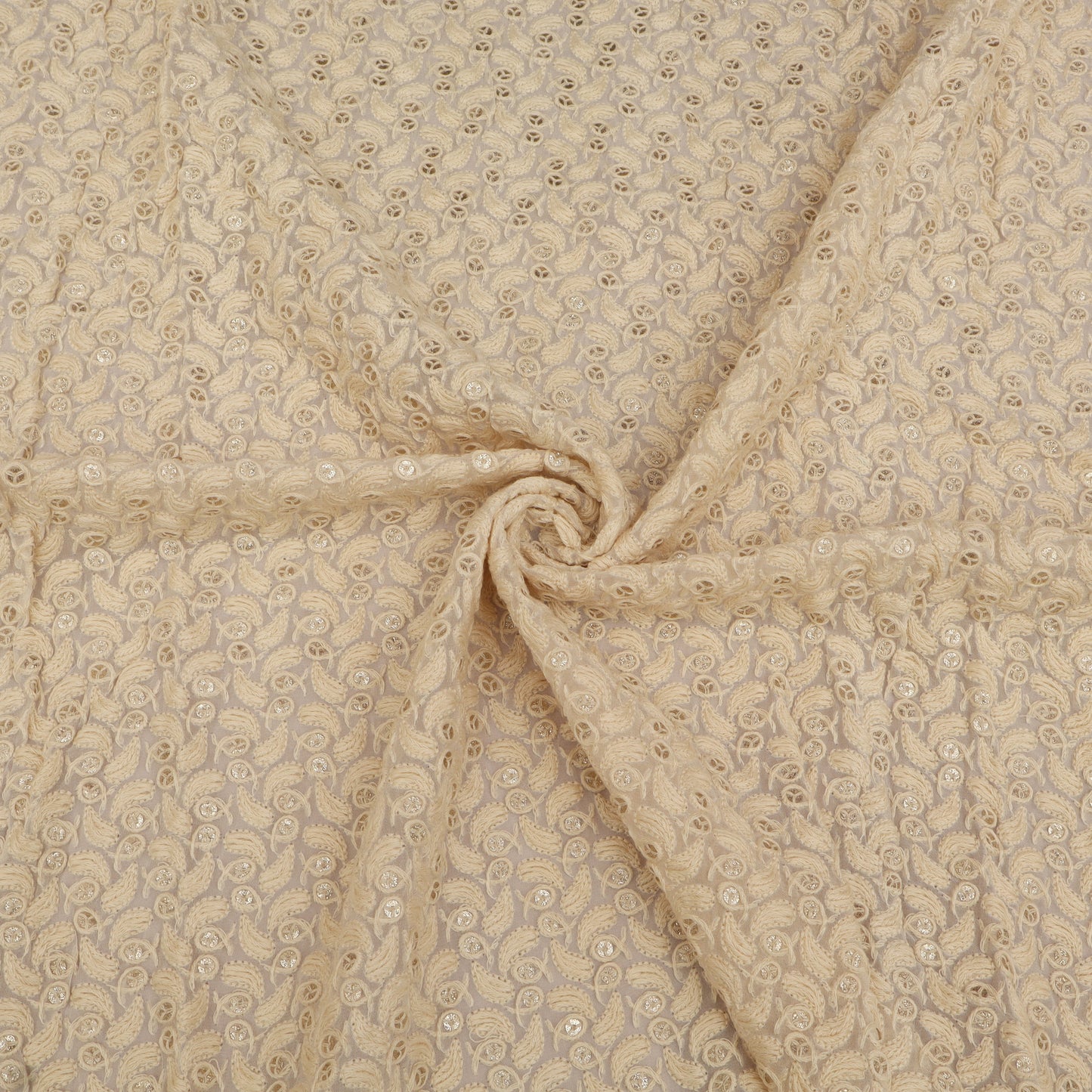 Beige fabric with a subtle pattern, possibly floral or paisley, in a close-up view.