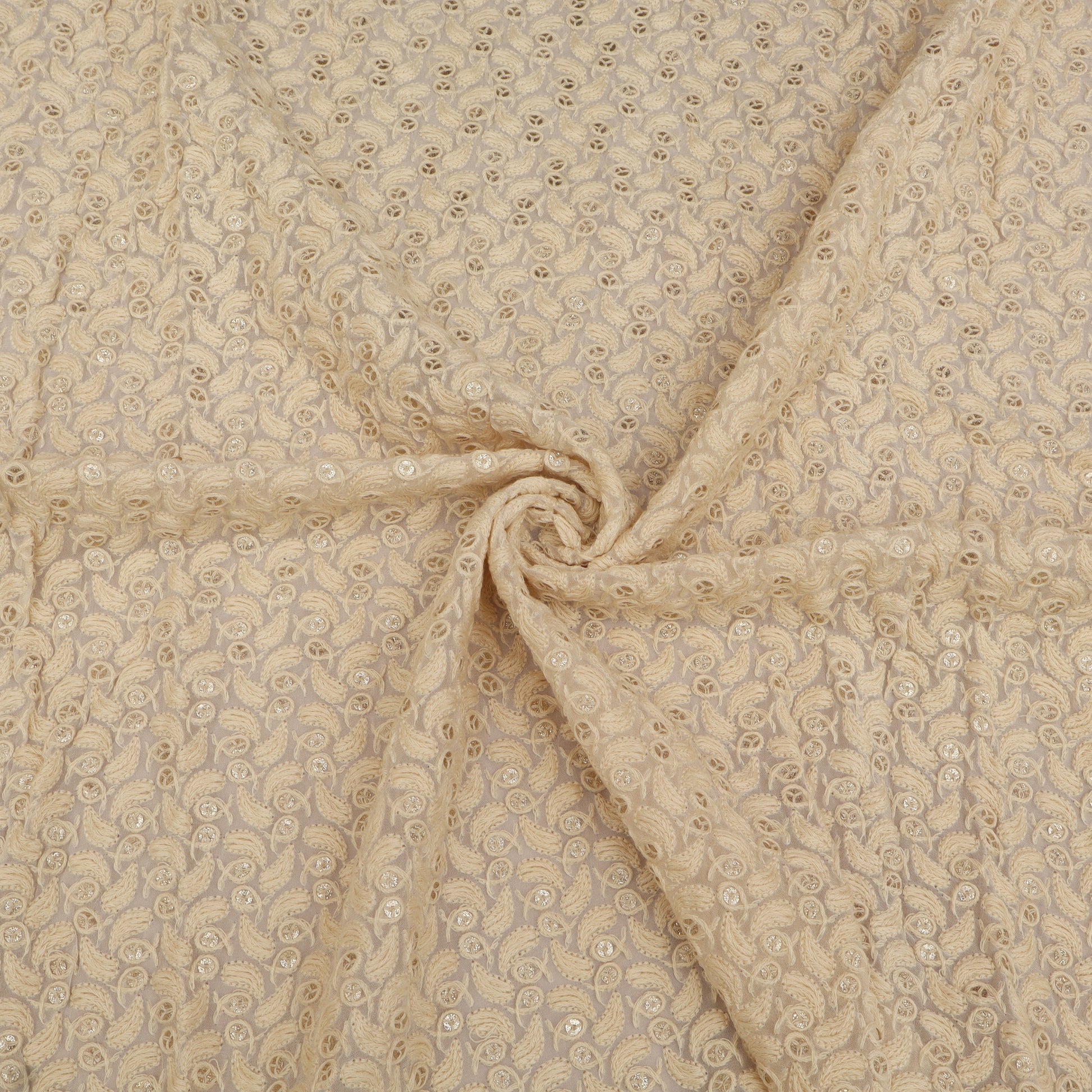 Beige fabric with a subtle pattern, possibly floral or paisley, in a close-up view.
