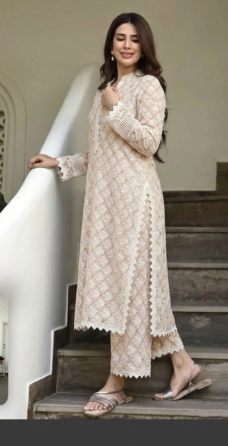 Woman in a beige lace outfit standing on a staircase