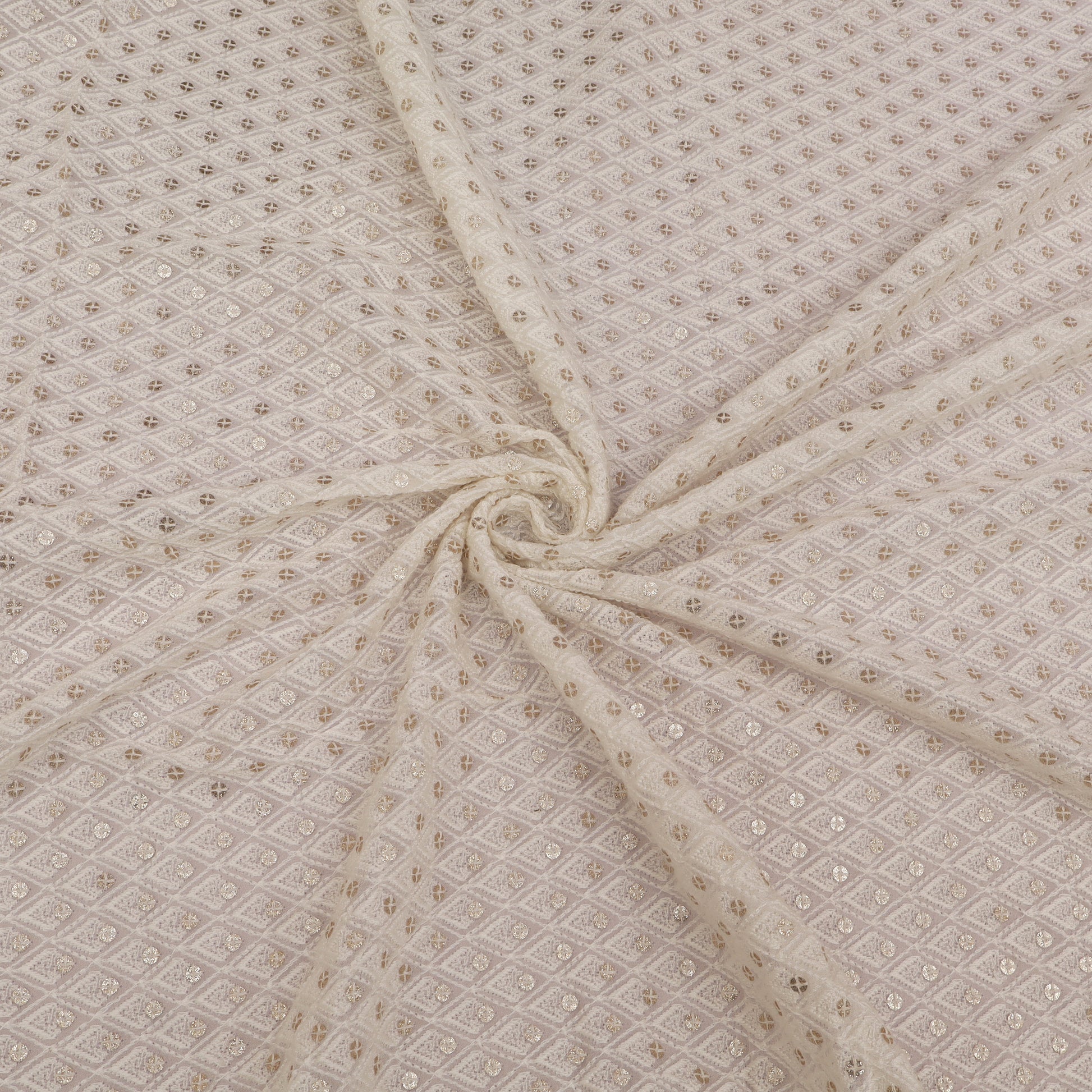 Beige fabric with a subtle pattern, folded in a way that creates a swirl.