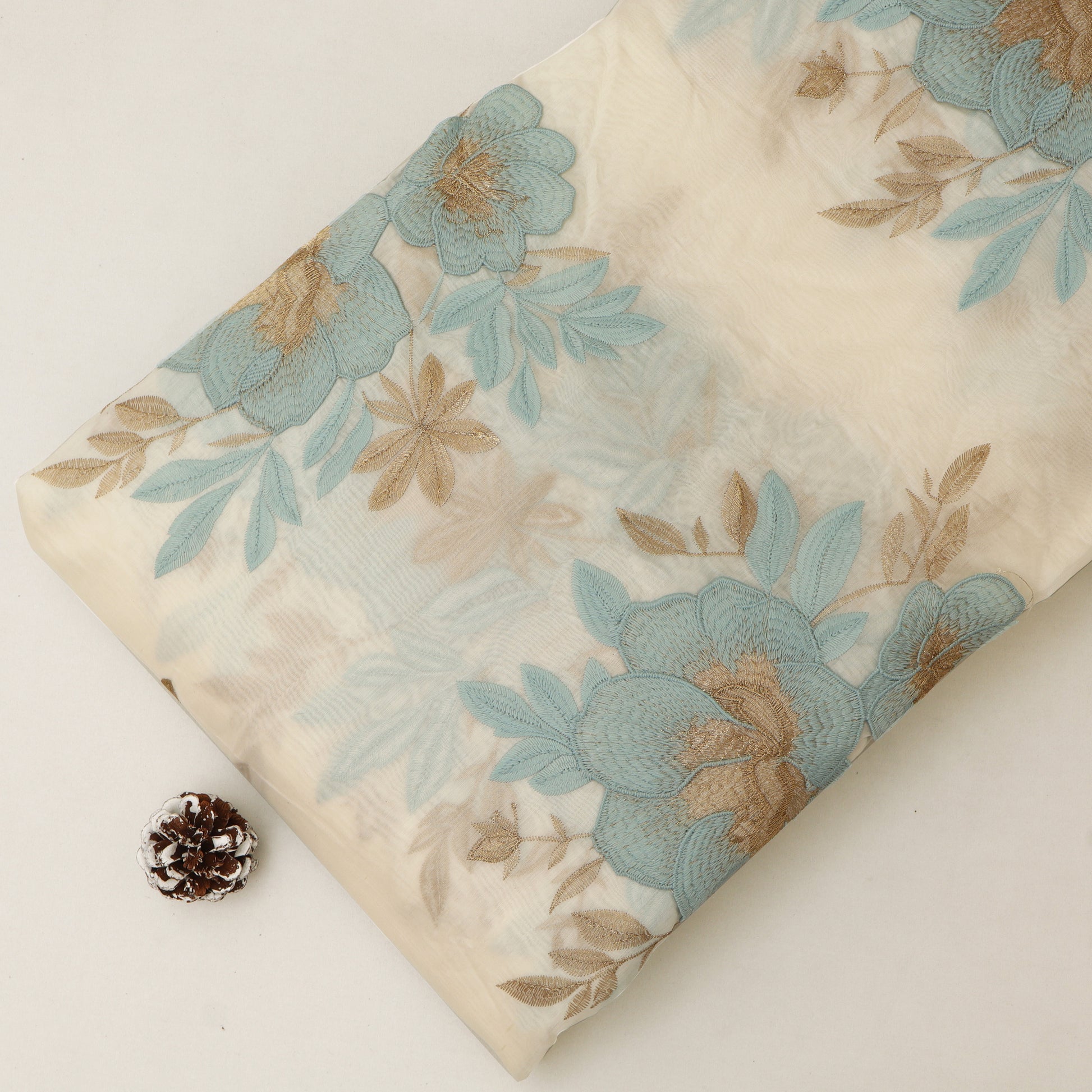 Floral-patterned fabric with blue and brown flowers on a white background