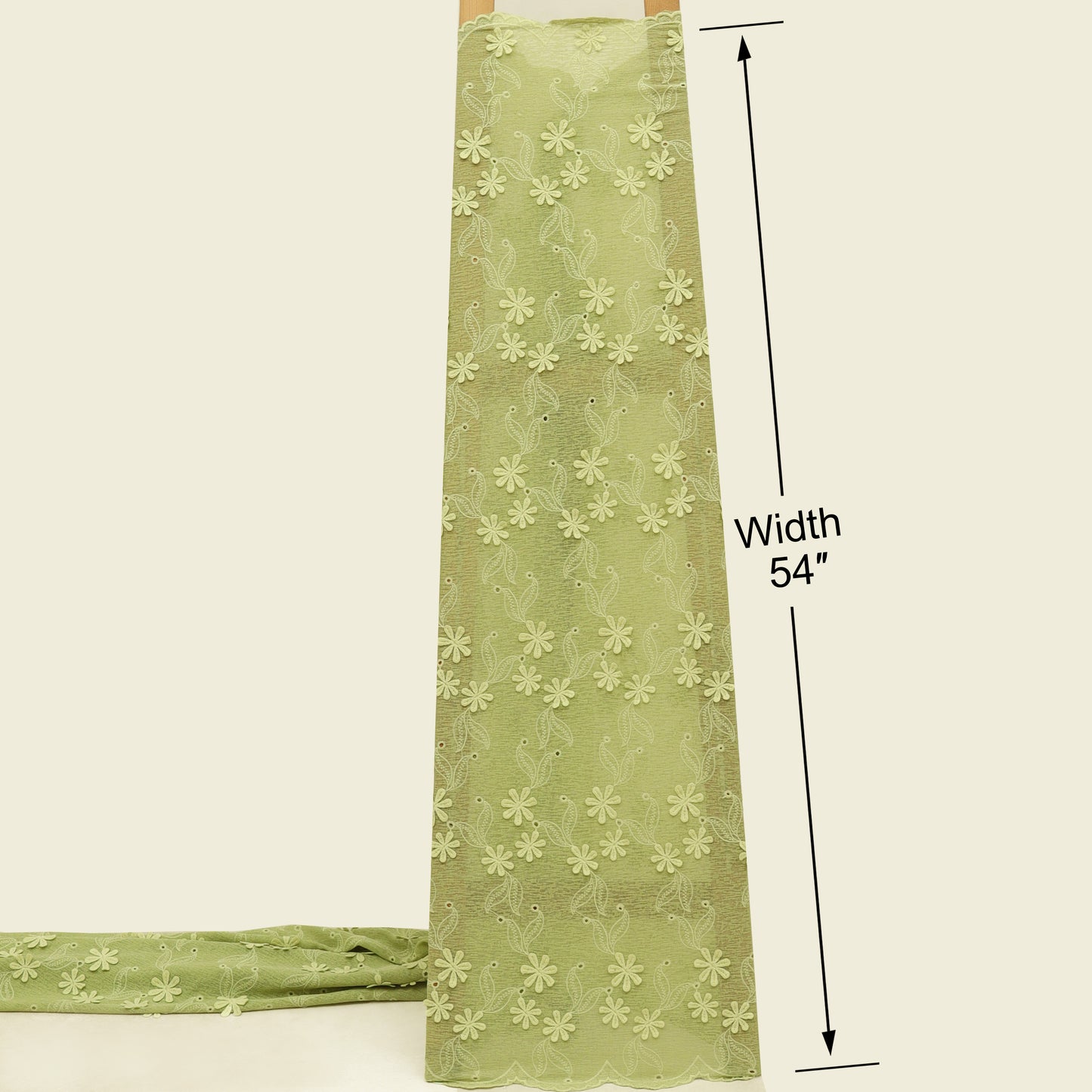 Green fabric with floral pattern and measurement label on a beige background