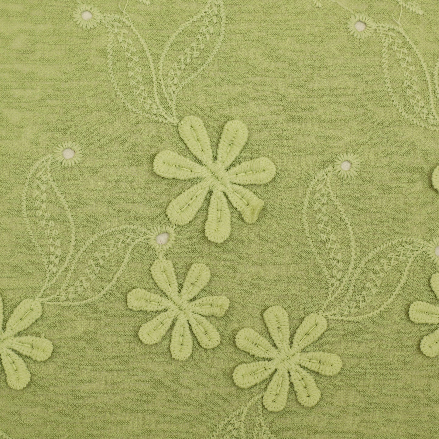 Green fabric with embroidered flowers and leaves