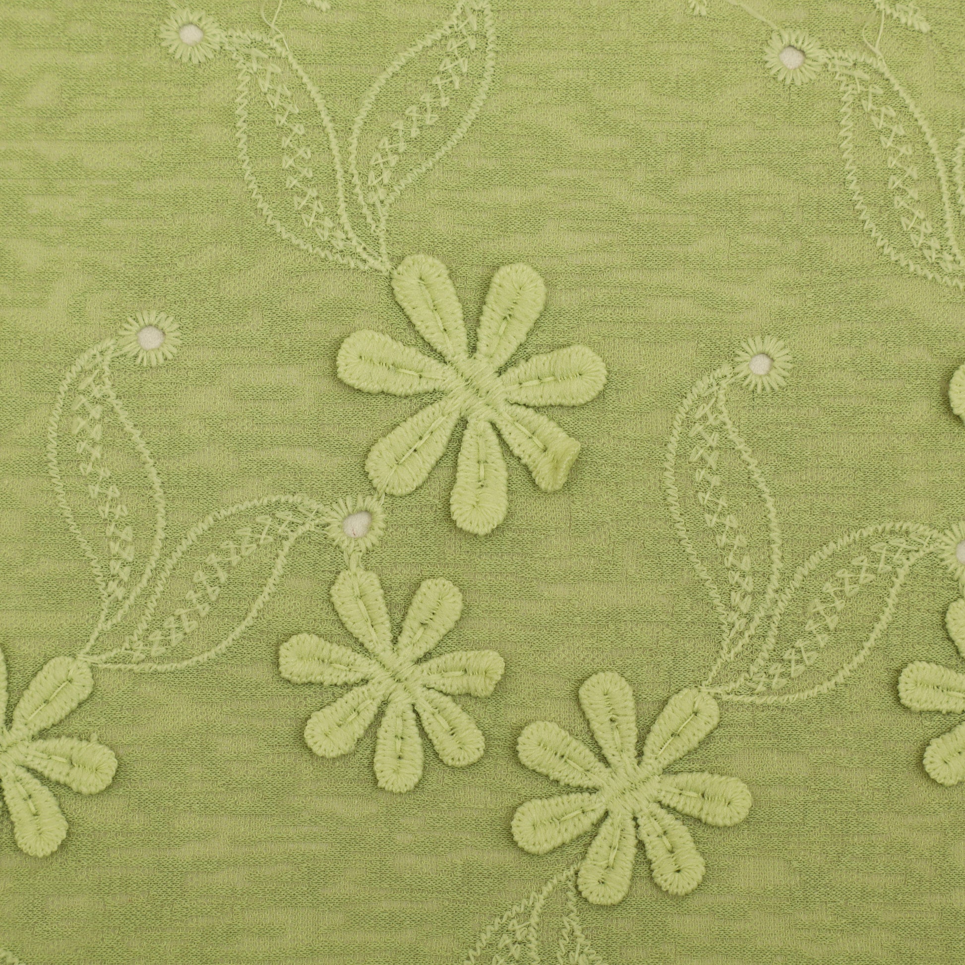 Green fabric with embroidered flowers and leaves
