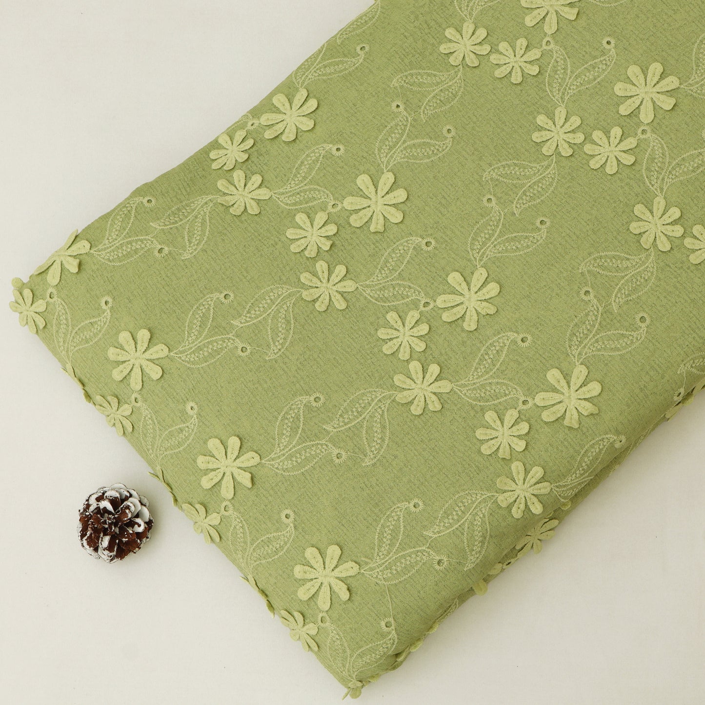 Green fabric with floral pattern on a white background