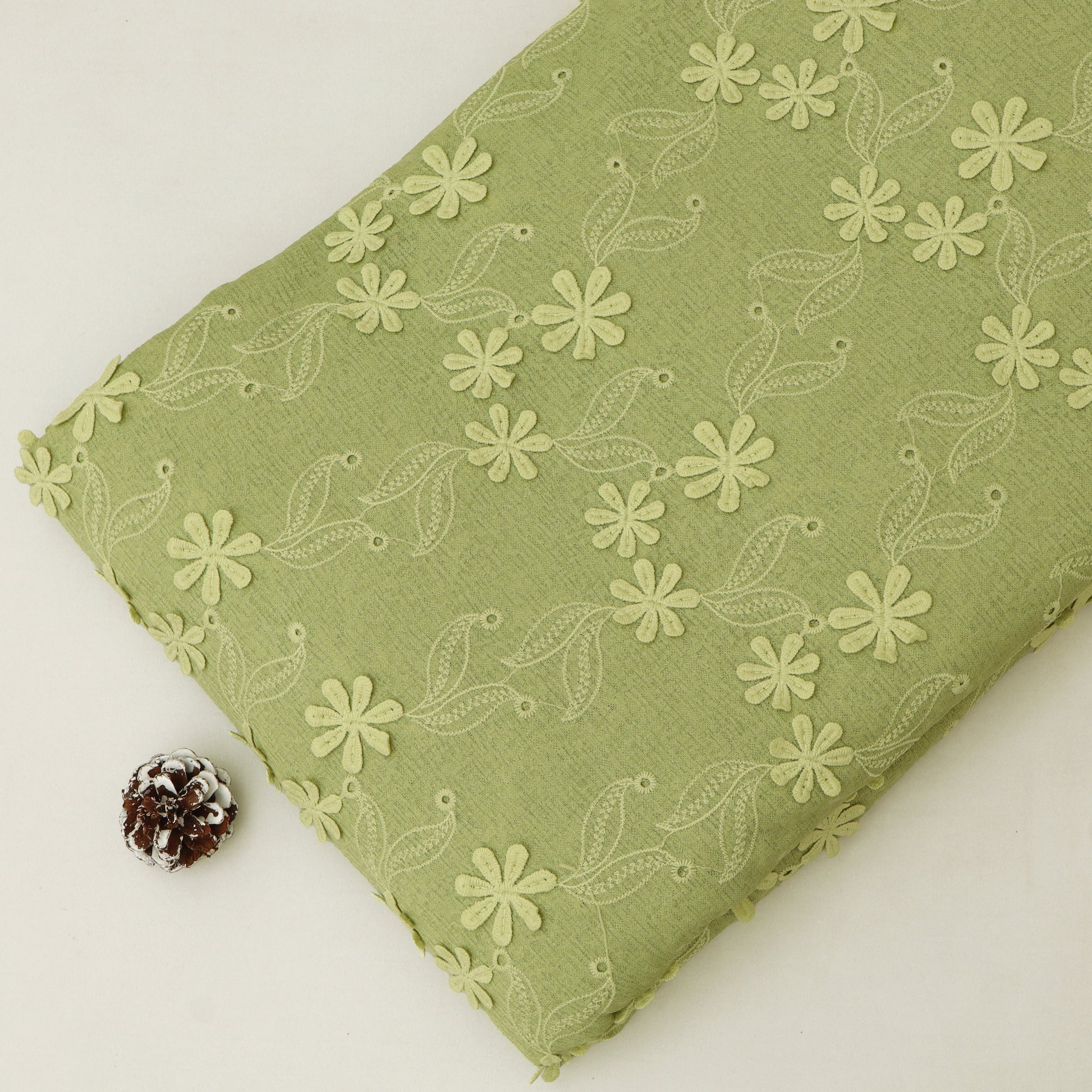 Green fabric with floral pattern on a white background