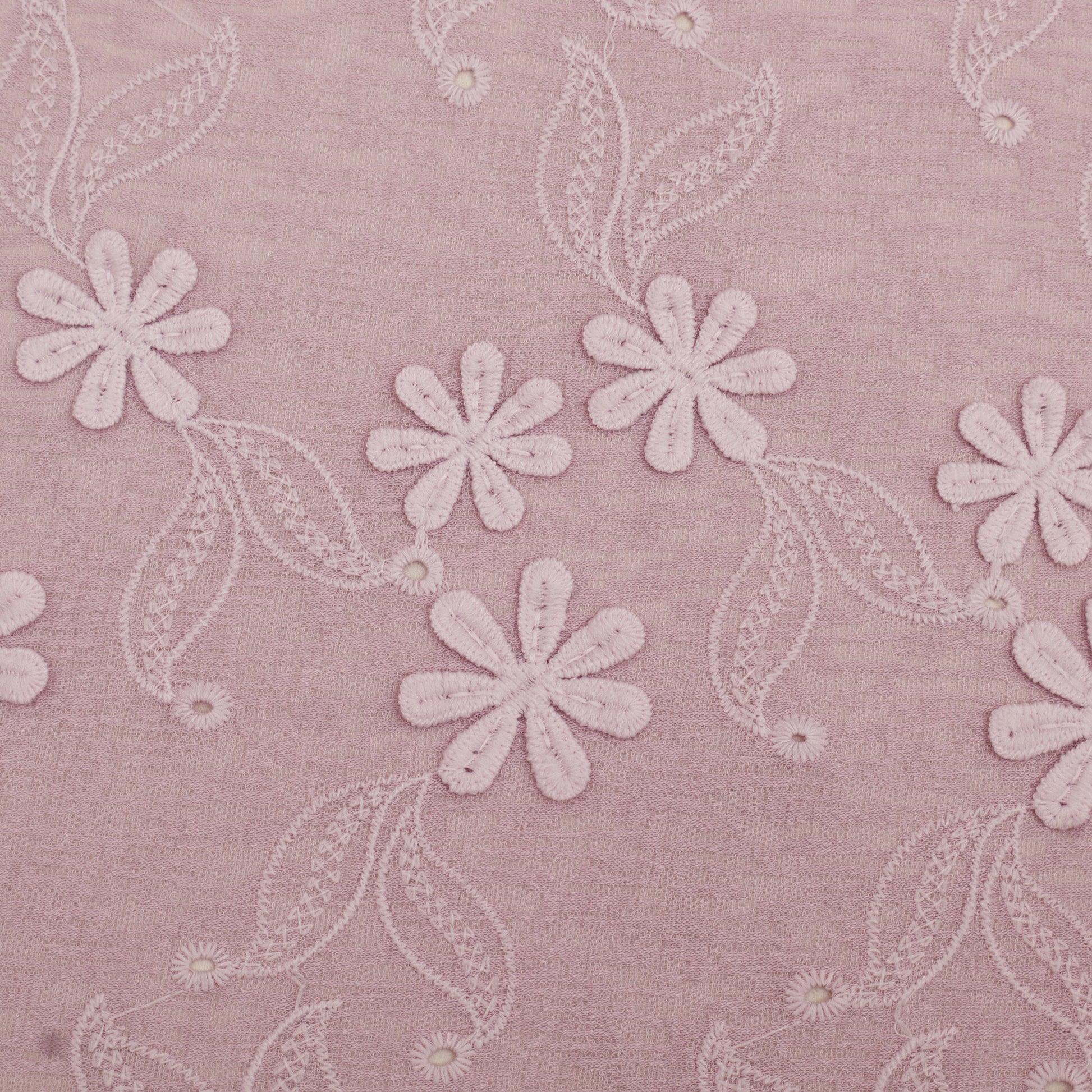 Embroidered floral pattern on a pink fabric background