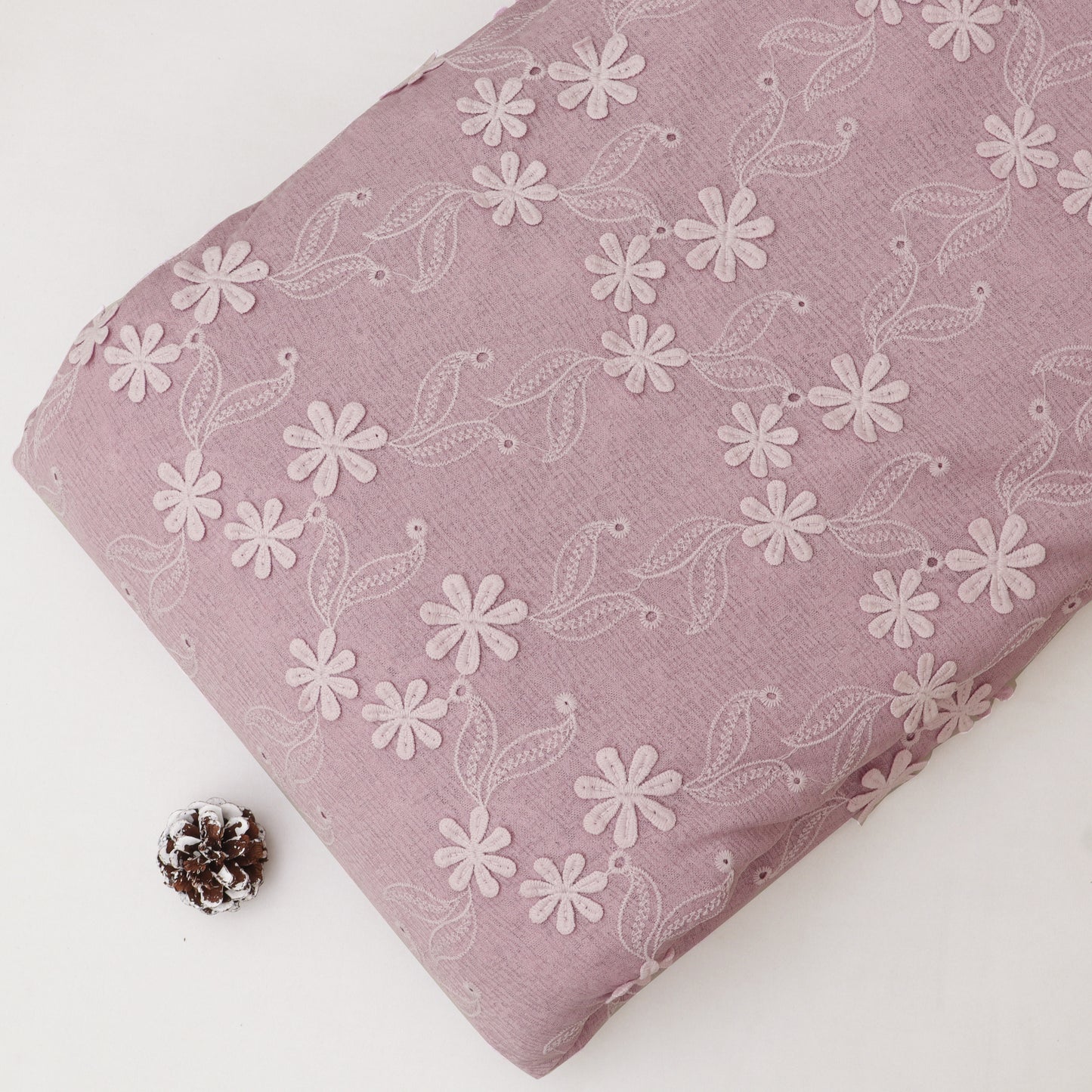 Pink fabric with white floral pattern on a white background
