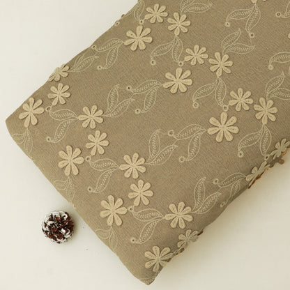 Brown fabric with floral embroidery on a white background