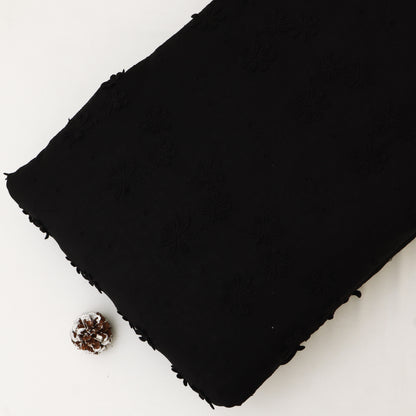 Black fabric with frayed edges on a white background