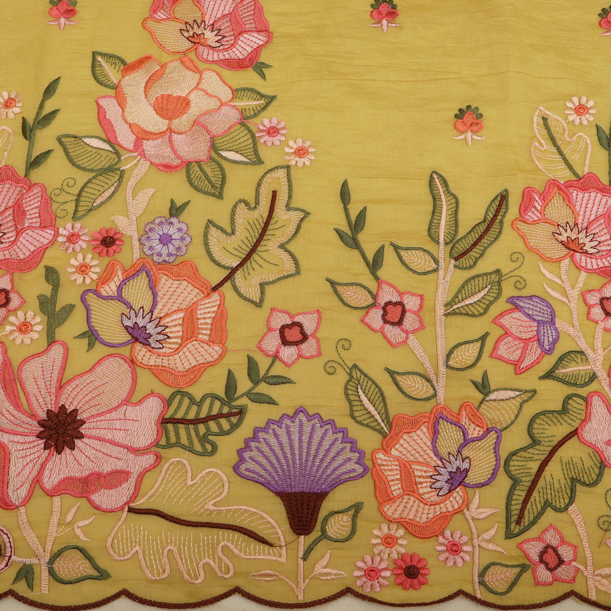Close-up of embroidered floral pattern on fabric with a yellow background