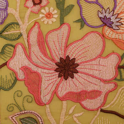 Close-up of embroidered floral design on fabric with pink flower and green leaves.
