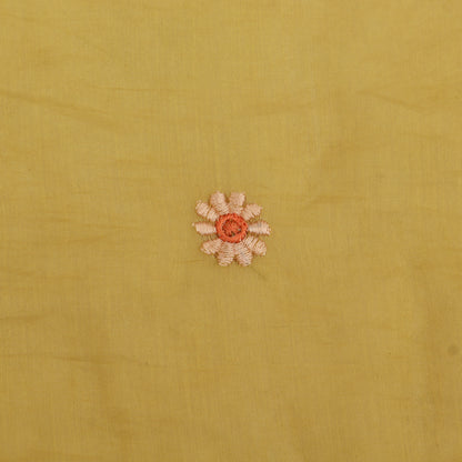 Small embroidered flower on a yellow fabric background