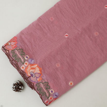 Pink fabric with floral embroidery on a white background