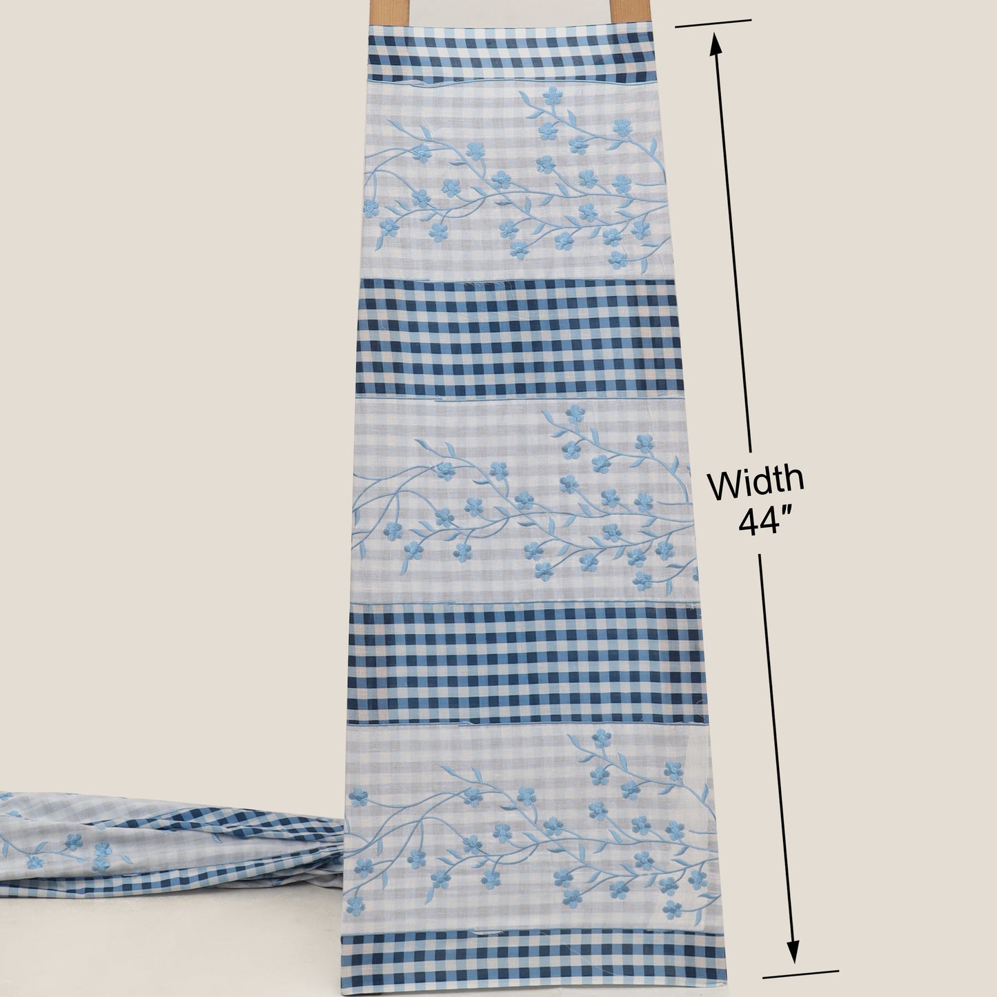 Blue and white checkered fabric with floral embroidery, displayed on a white background.