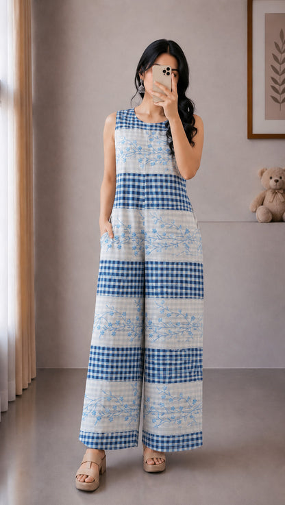 Woman taking a mirror selfie wearing a blue and white checkered dress in a room.