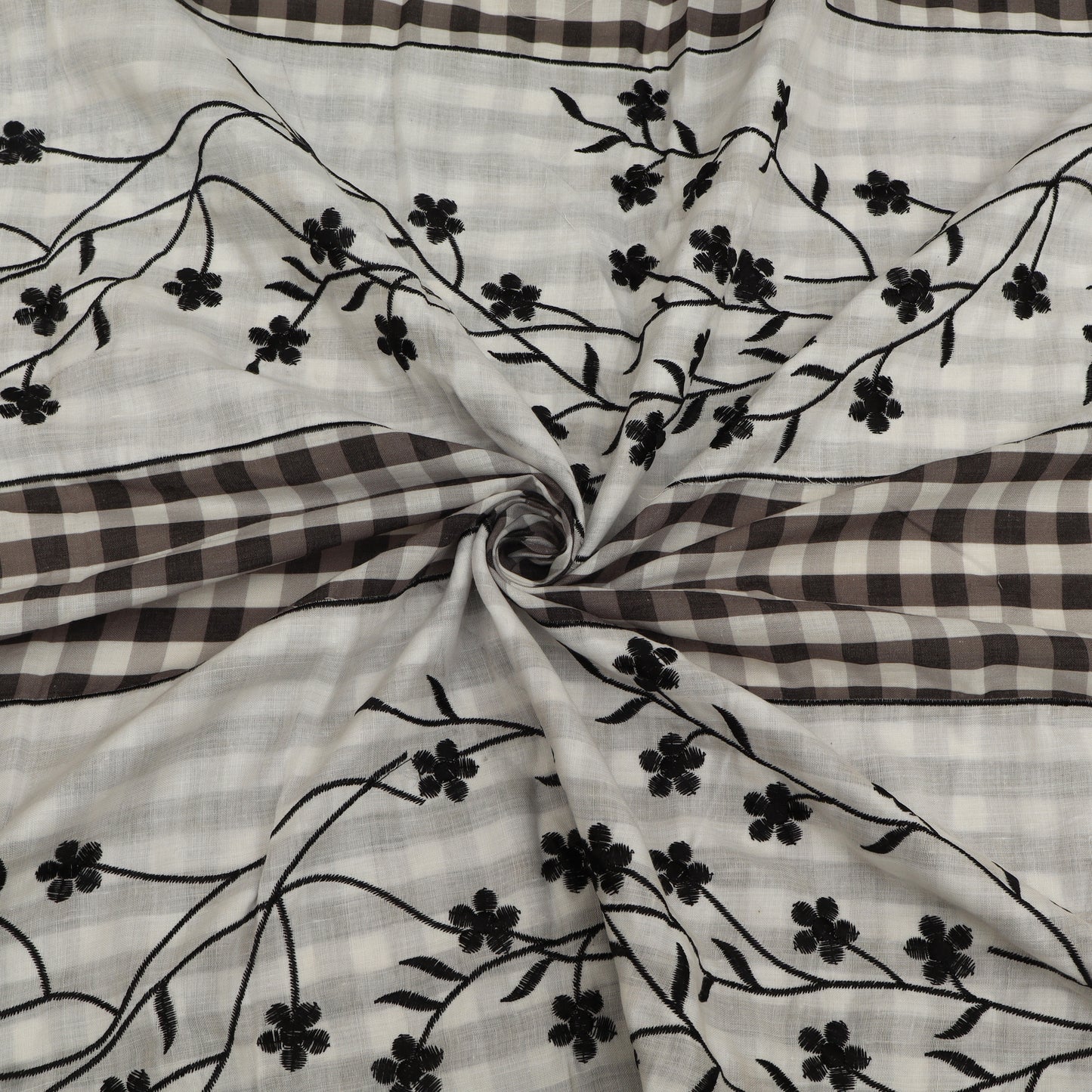 Fabric with black floral embroidery on a checkered pattern