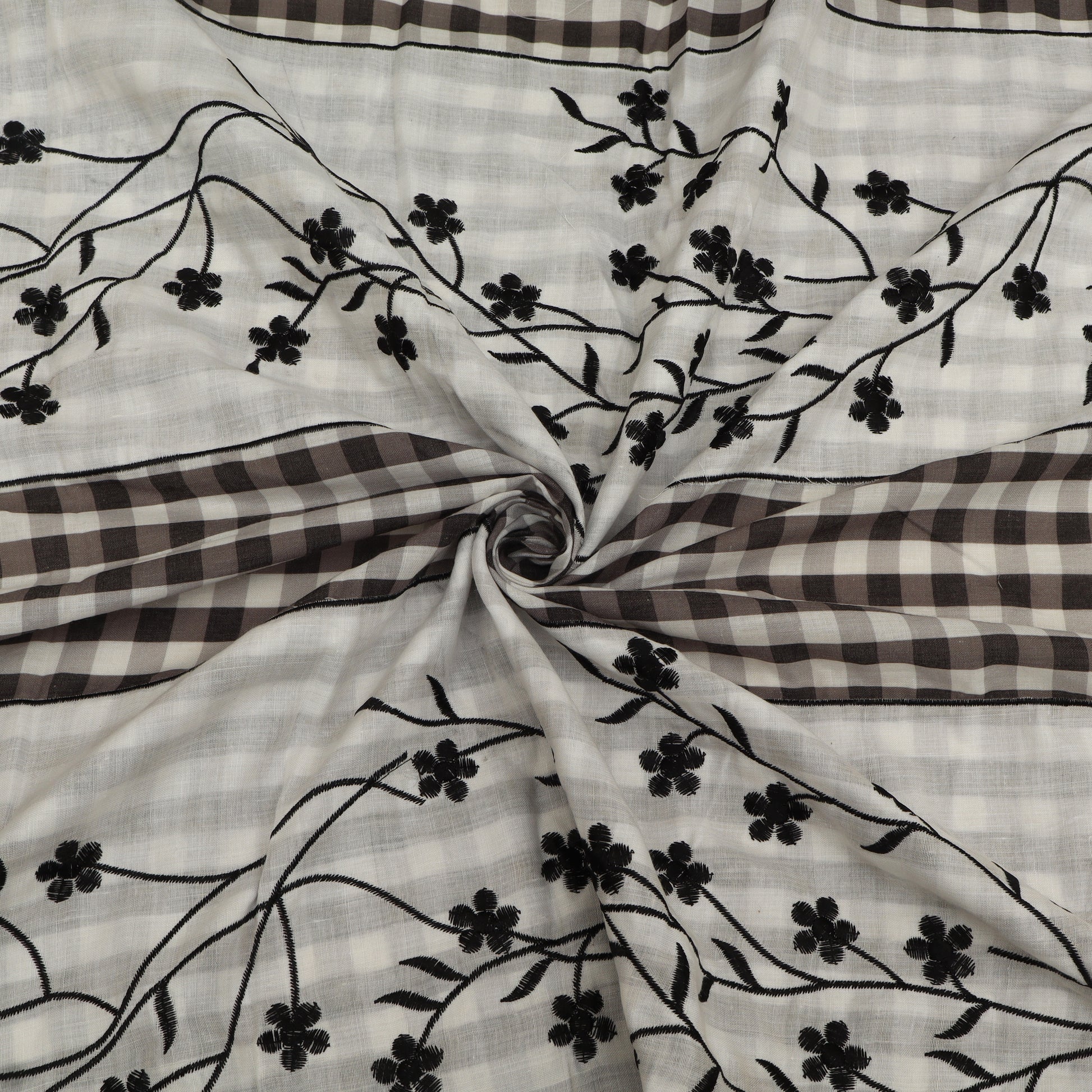 Fabric with black floral embroidery on a checkered pattern